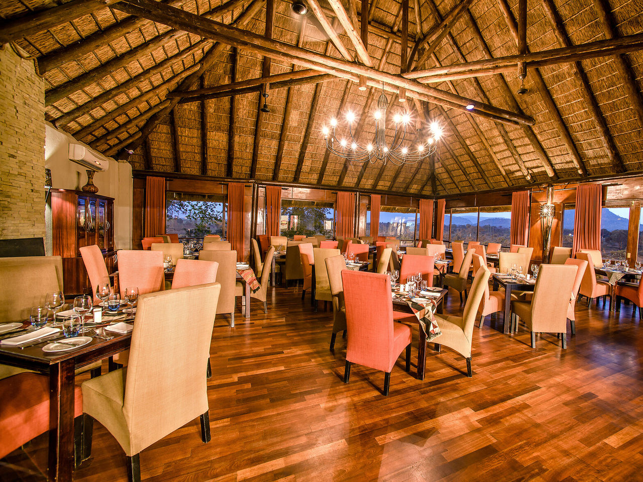 El restaurante Buhlebethu, del Hotel 4 Estrellas en Kruger Park, tiene varias mesas y decoración típica africana
