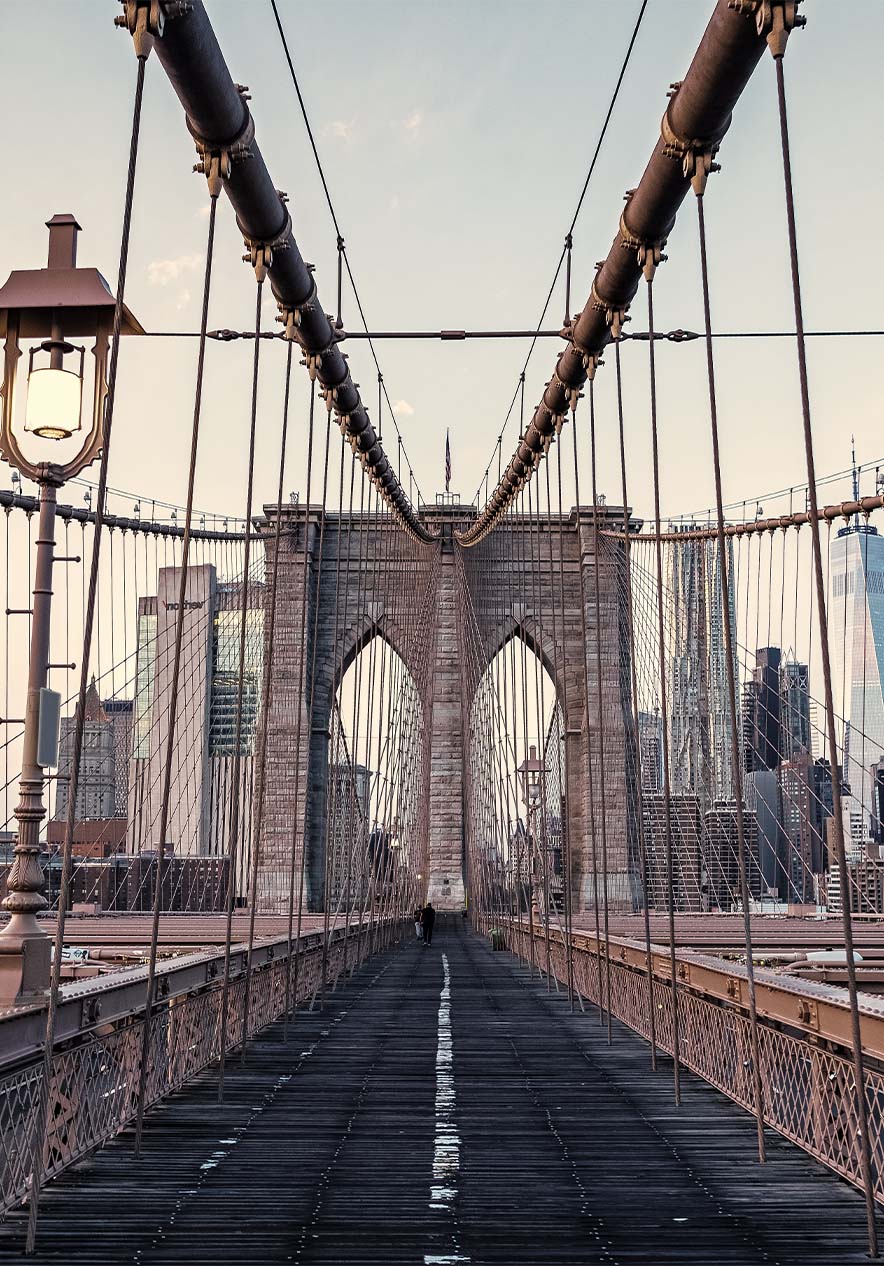 Vista panorámica del puente de Brooklyn, con cables de acero y estructura de hierro bajo un cielo azul