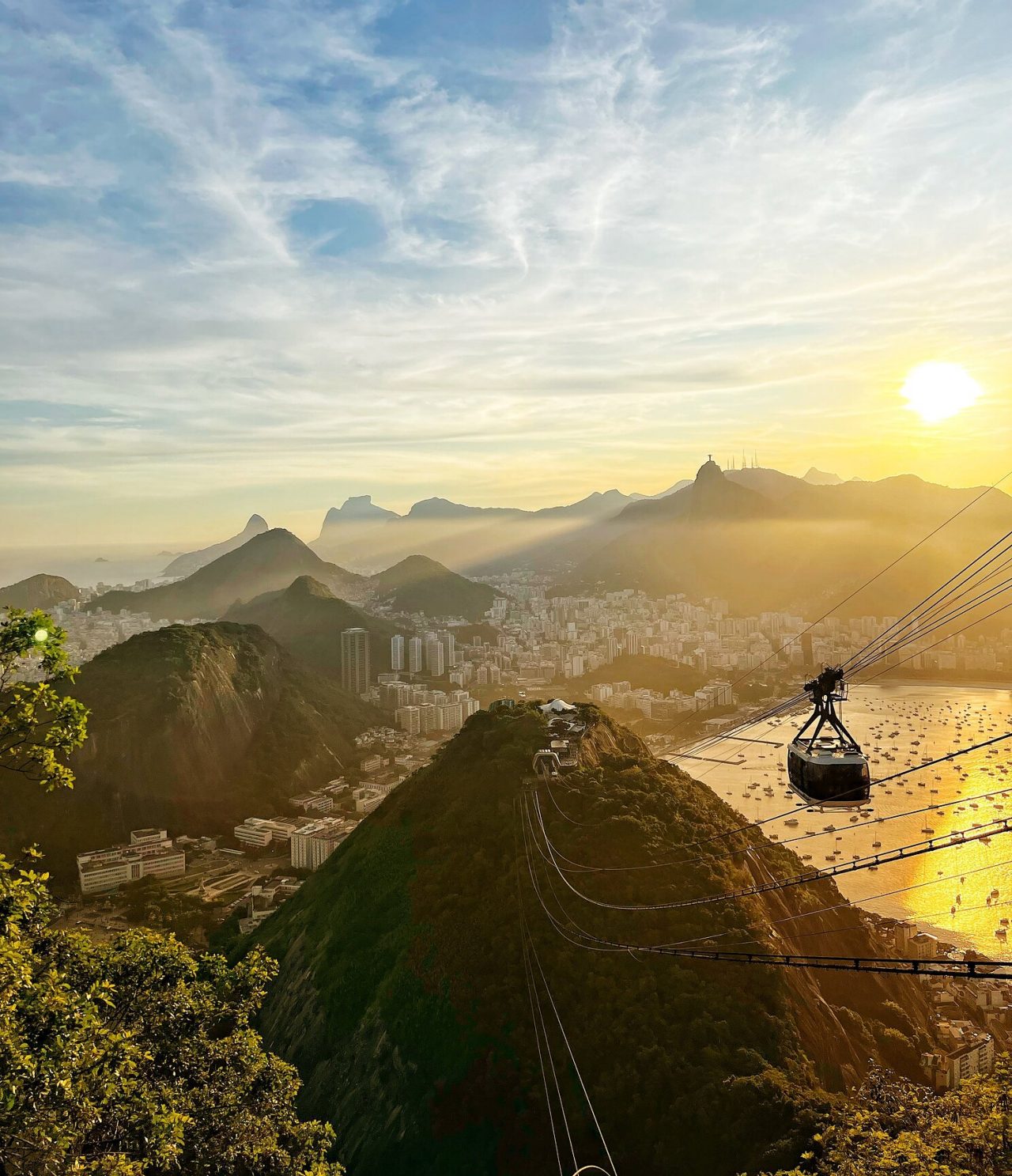 Vista aérea de Río de Janeiro, con un teleférico dirigiéndose hacia una colina, con la ciudad y la playa al fondo