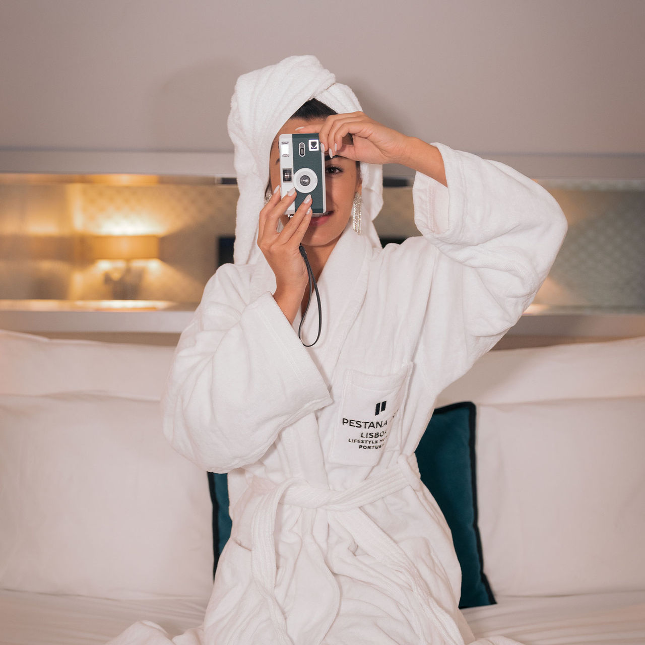 Chica tomando una fotografía con una cámara digital en una habitación del Pestana CR7 Lisboa