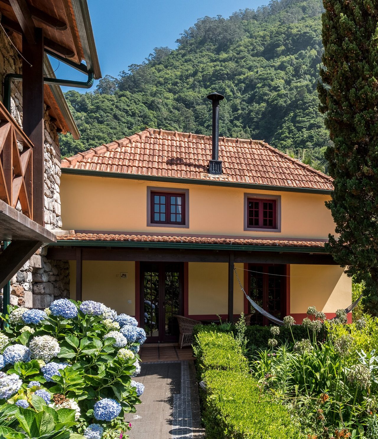 El restaurante Roseiral, del Turismo Rural en Madeira, está en medio de la naturaleza, con jardín y montañas al fondo