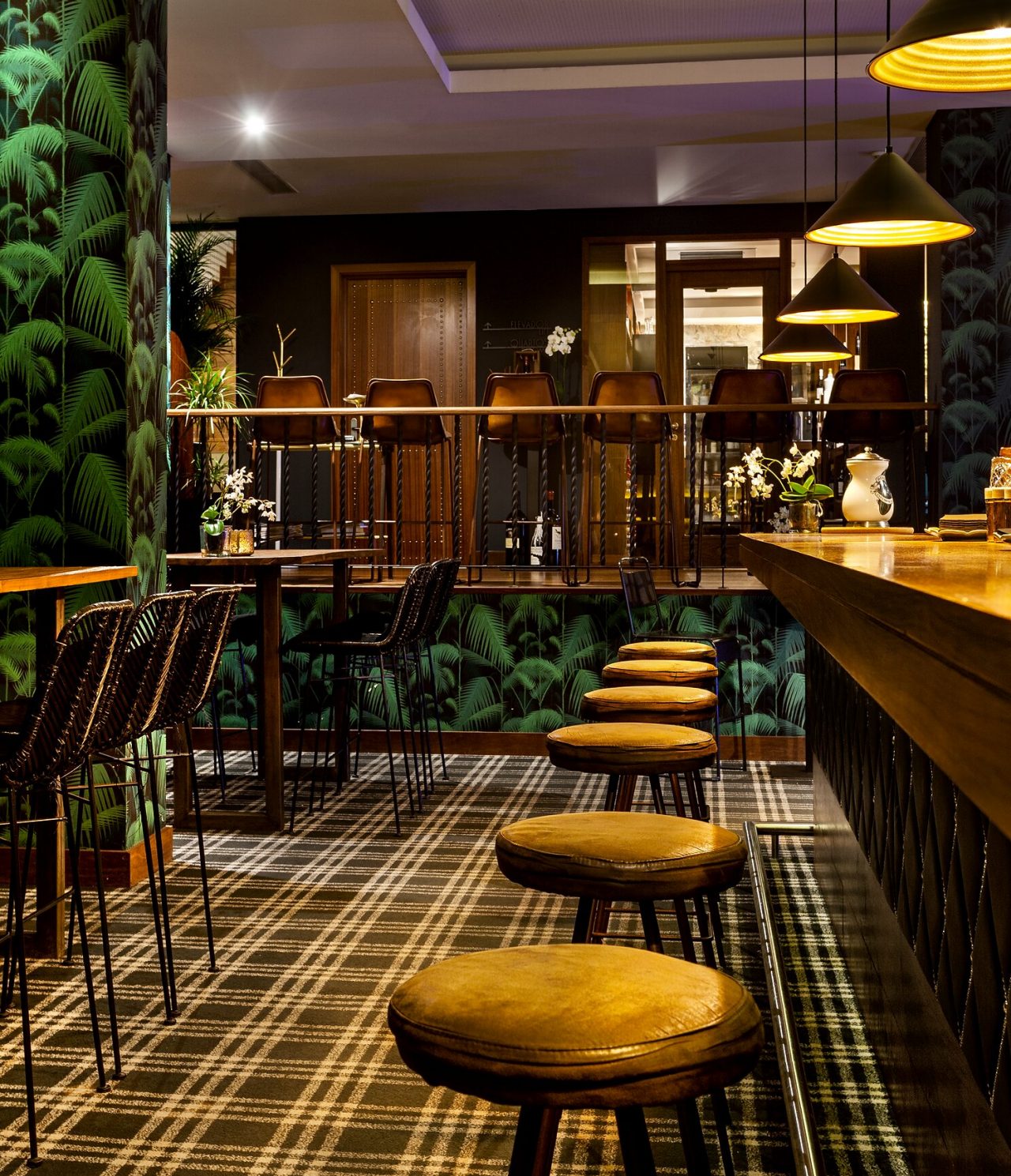 El Rib Bar del hotel 5 estrellas en el centro de Oporto, tiene un mostrador con bancos altos y papel tapiz tropical