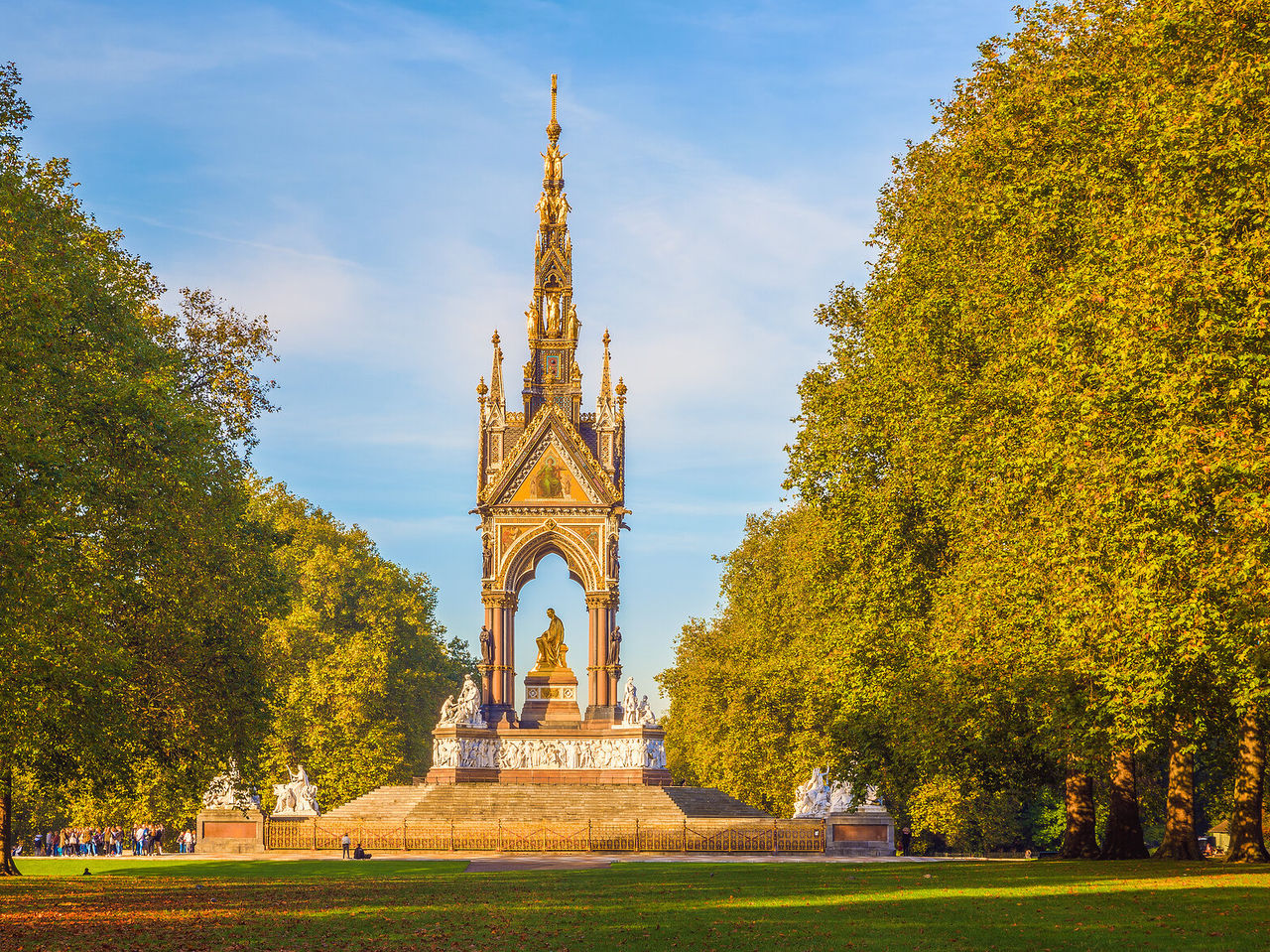 Vista de un parque al icónico Albert Memorial, con su estatua dorada central y detalles esculpidos