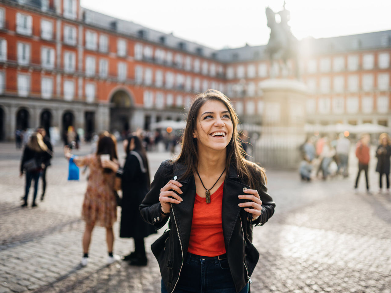 Rapariga feliz com mochila as costas deambula pela Plaza Mayor, no centro histórico de Madrid