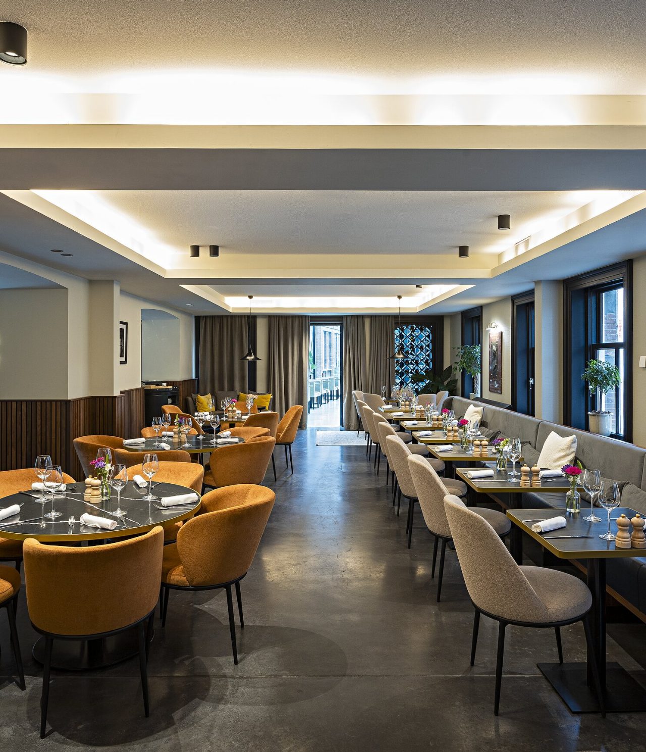 O restaurante Archive, do Hotel 5 Estrelas em Amesterdão, tem um espaço amplo, com mesas redondas e quadradas, com cadeiras