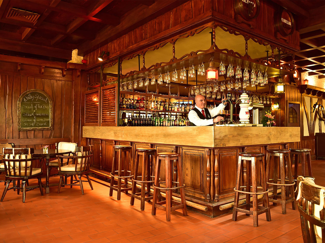 O bar The Pub, do Hotel 5 Estrelas na Madeira, tem um balcão rodeado por bancos altos e com várias bebidas