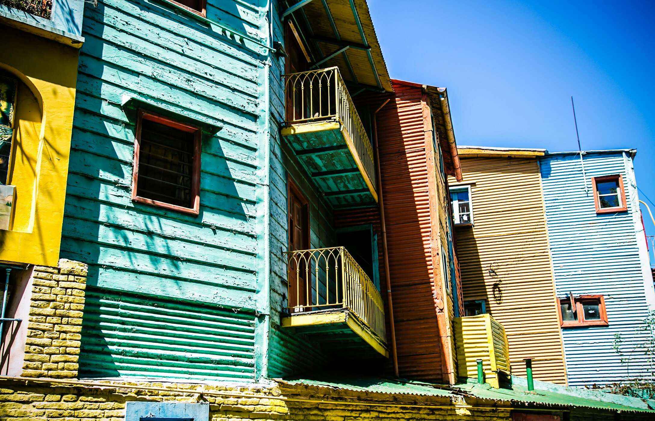 Facades of colorful wooden houses with balconies, typical of Caminito neighborhood in Buenos Aires, Argentina