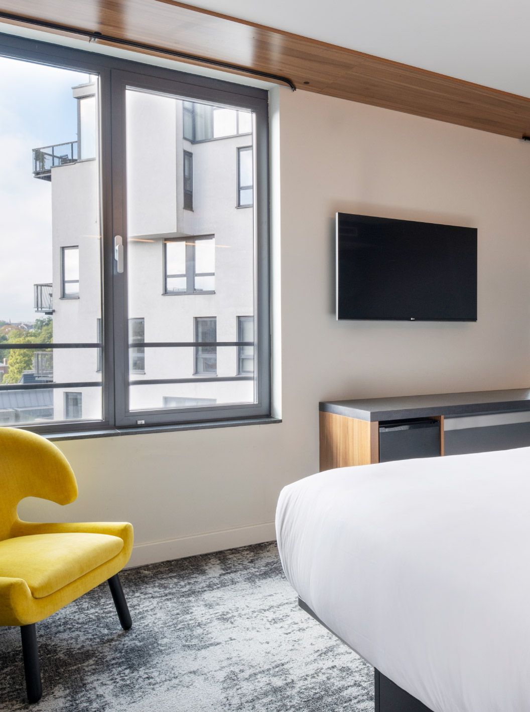 The Standard King at Pestana Brussels Schuman has a double bed, two windows, and a wall-mounted television