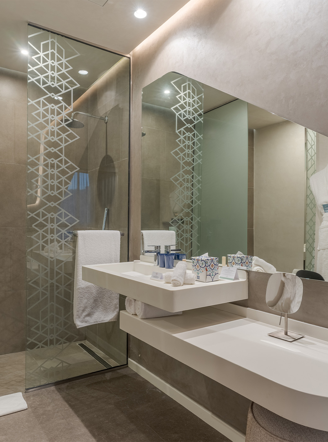 The CR7 Junior Suite Avenue at Pestana CR7 Marrakech has a bathroom with a sink, mirror, walk-in shower, and amenities