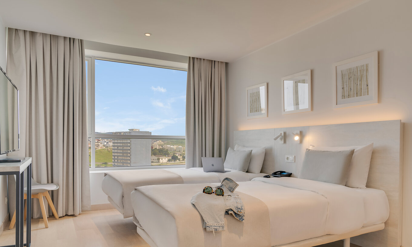 The Family Premium Suite of Pestana Tanger City Center features two separate beds with stone headboards and a window