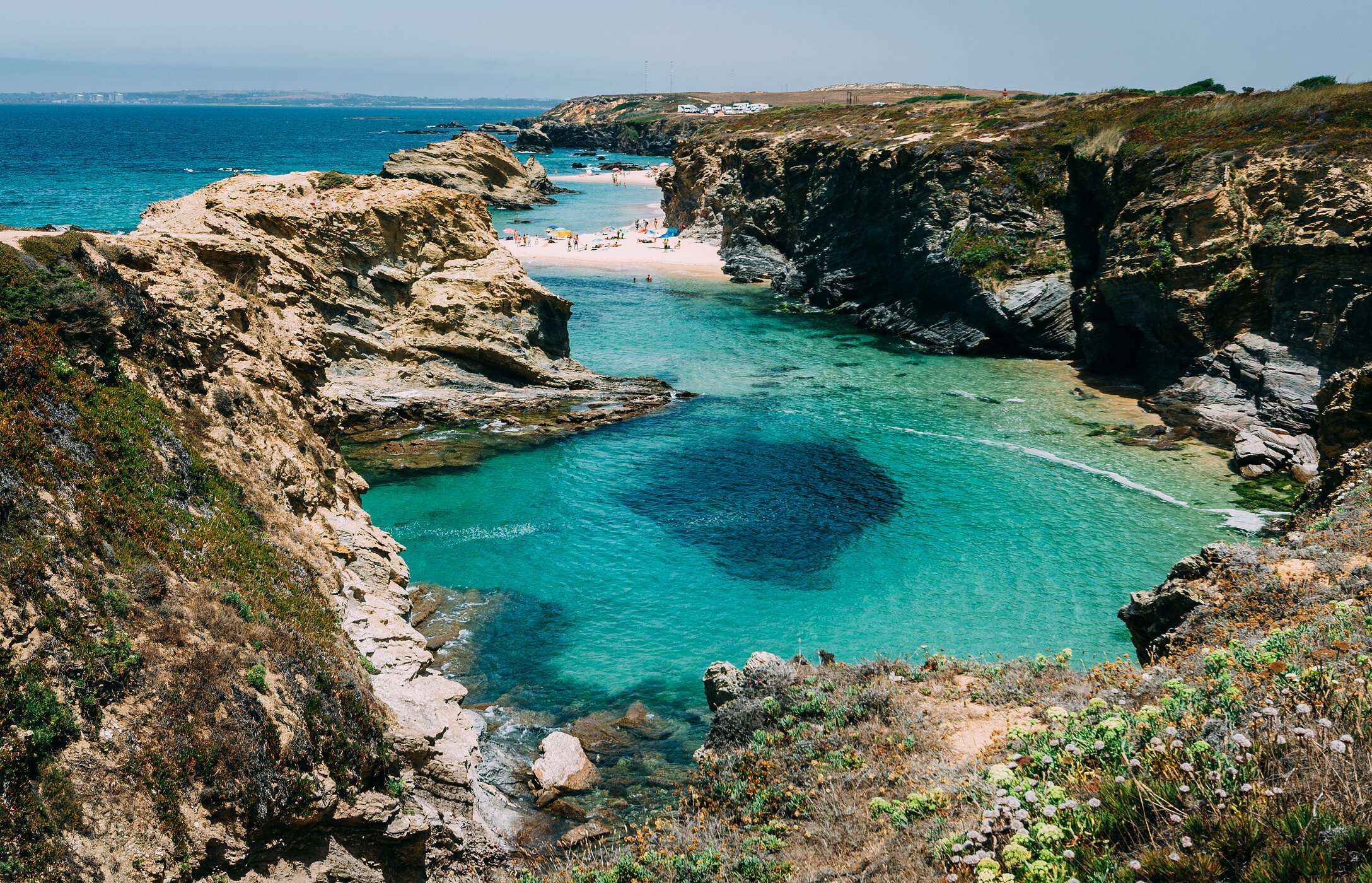 Paradise landscape of Praia da Samoqueira in Alentejo, hidden between cliffs and with crystal clear waters