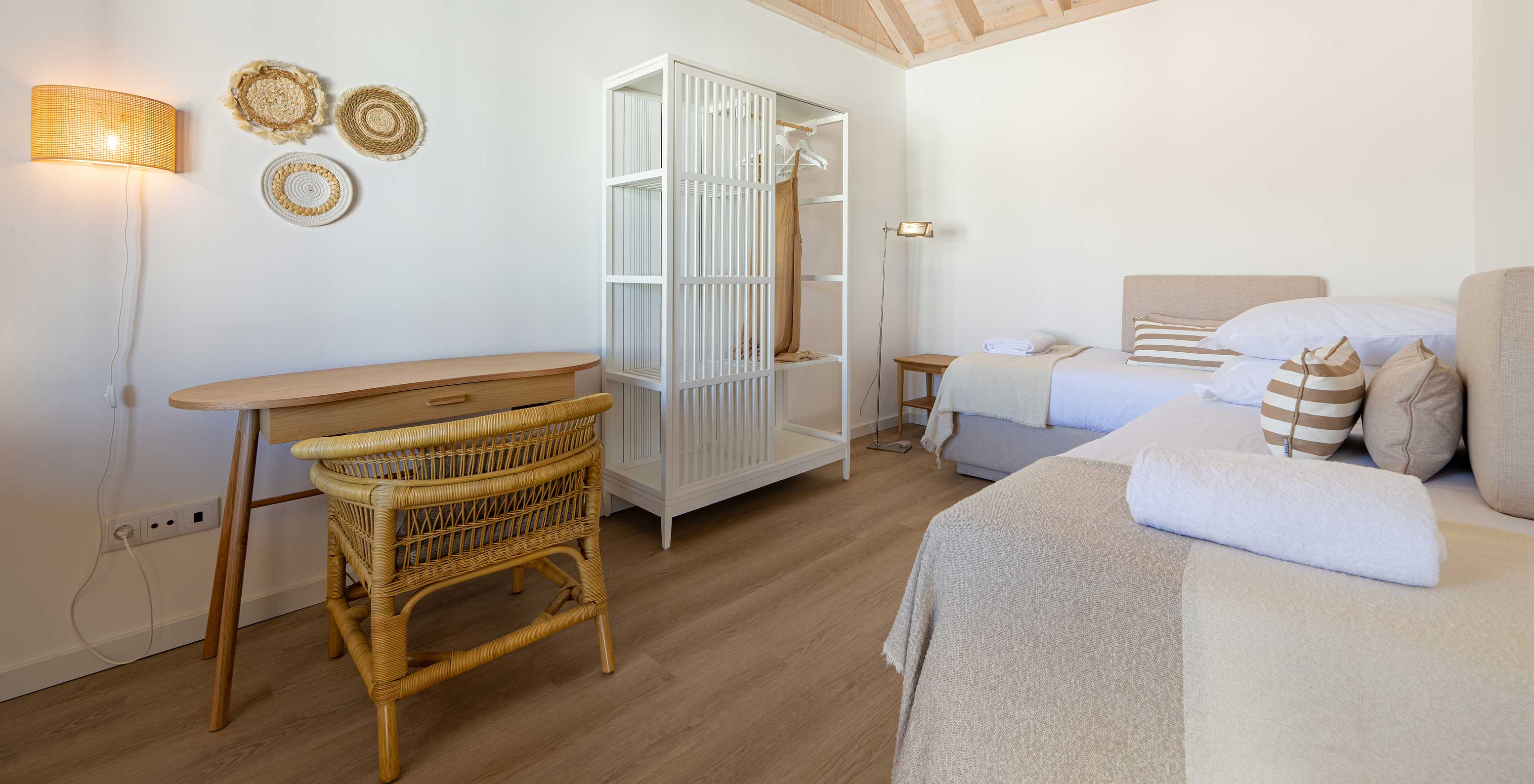 The Standard Villa at Pestana Comporta Village Residences has a bedroom with a bed, a table, and a wicker chair