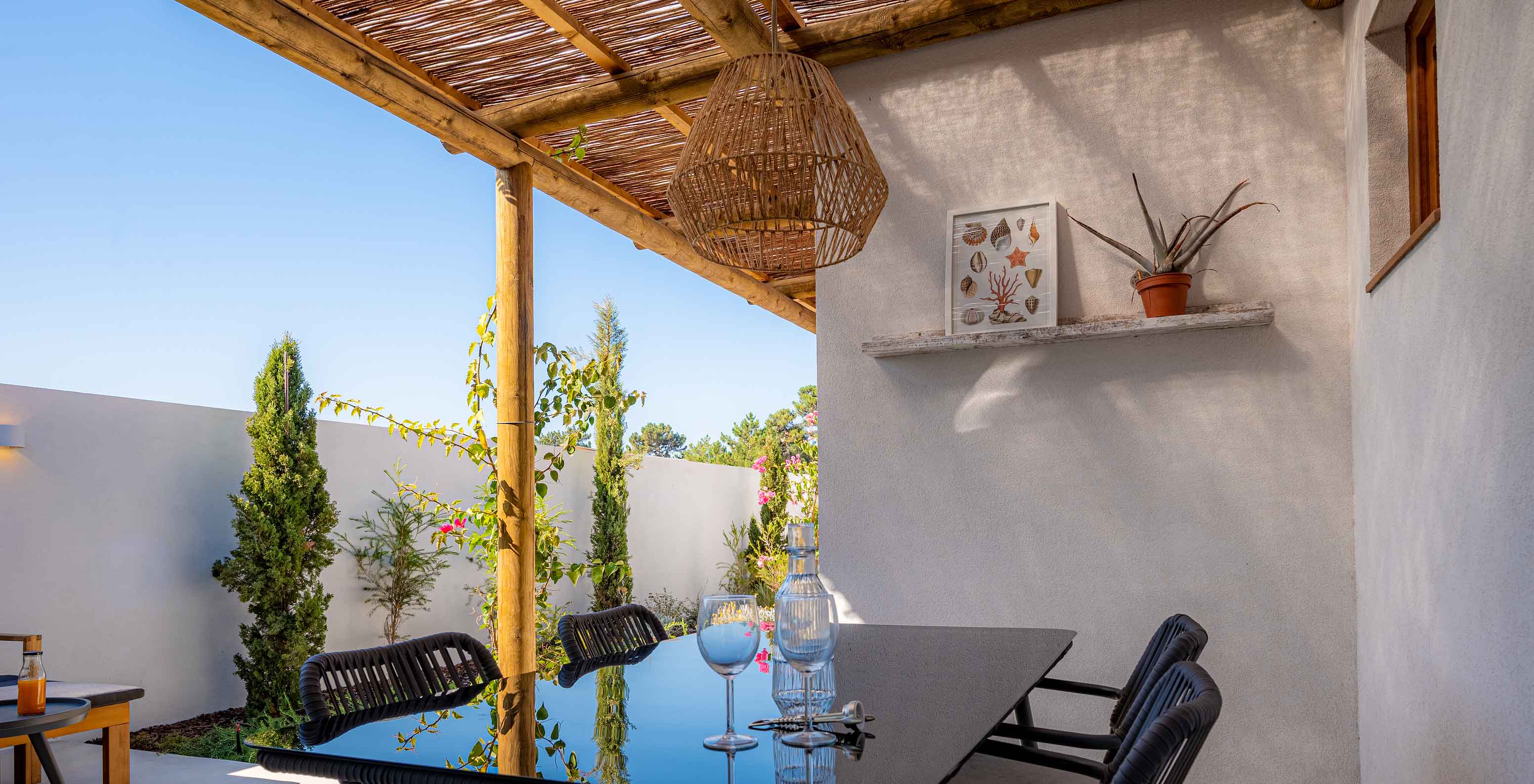 The Standard Villa T2 at Pestana Comporta Village Residences has an outdoor dining table under a pergola