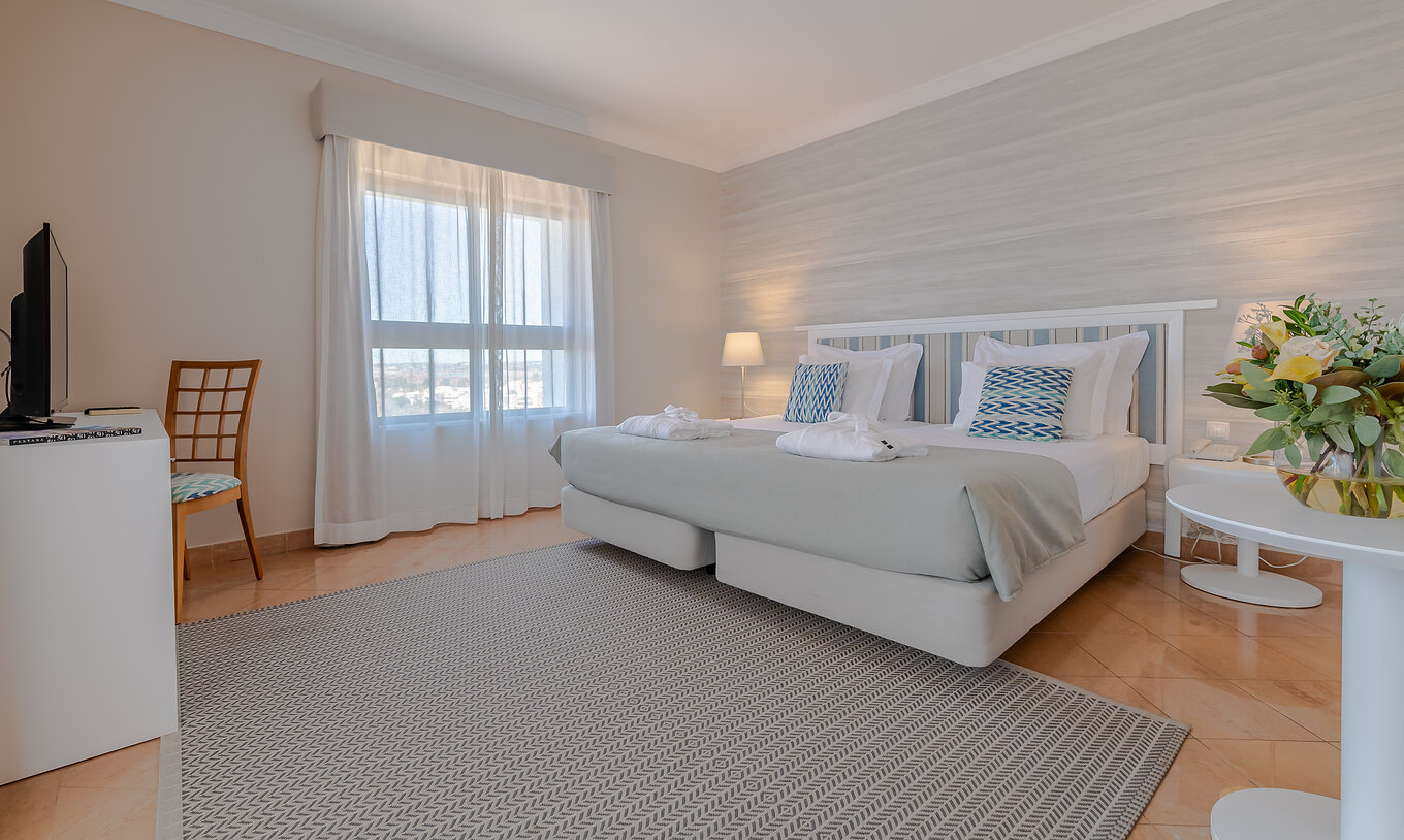 The T0 - Studio at Pestana Alvor Park has a double bed, a desk with a television, and a rug