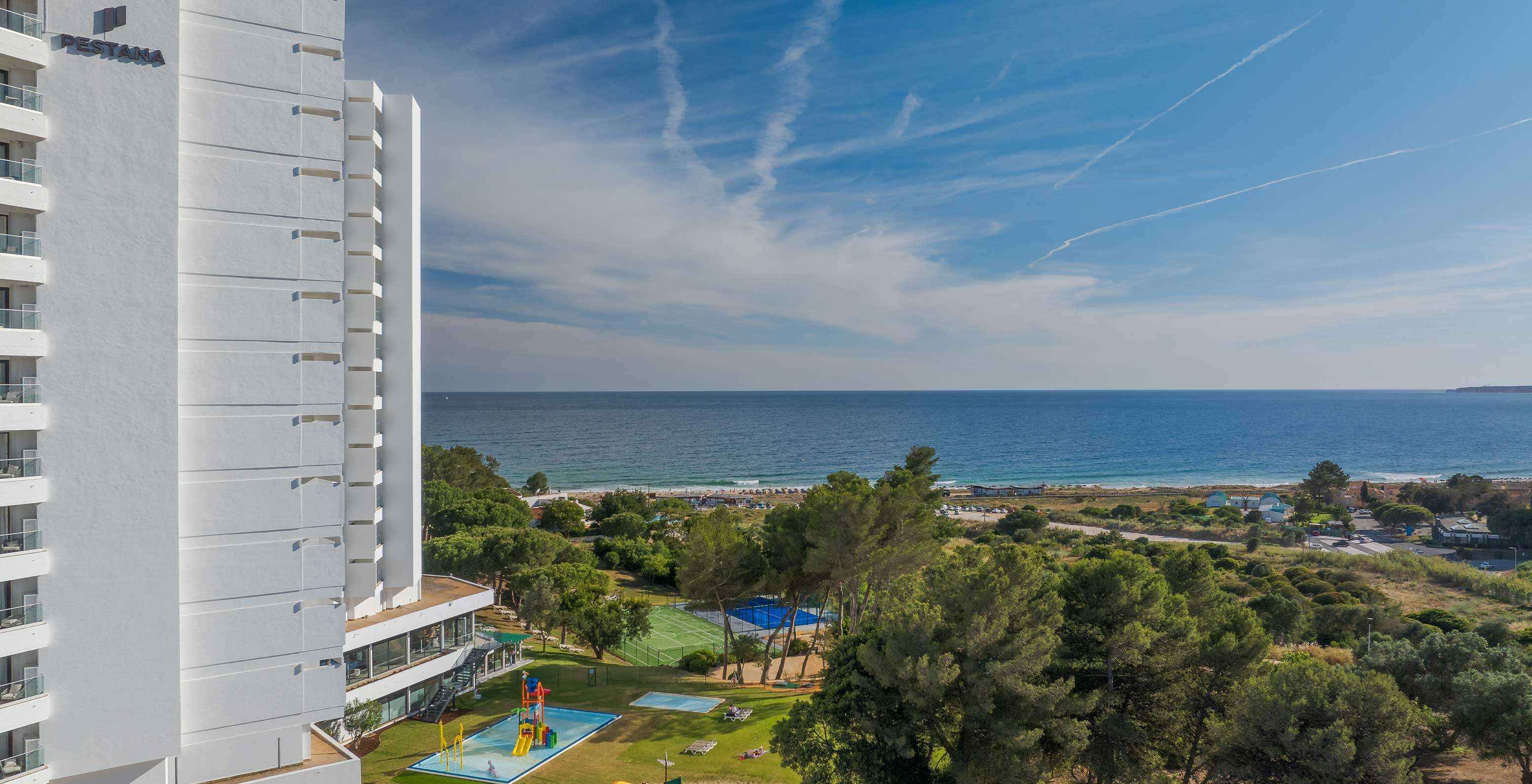 Pestana Blue Alvor Beach exterior, green vegetation and blue sea in background