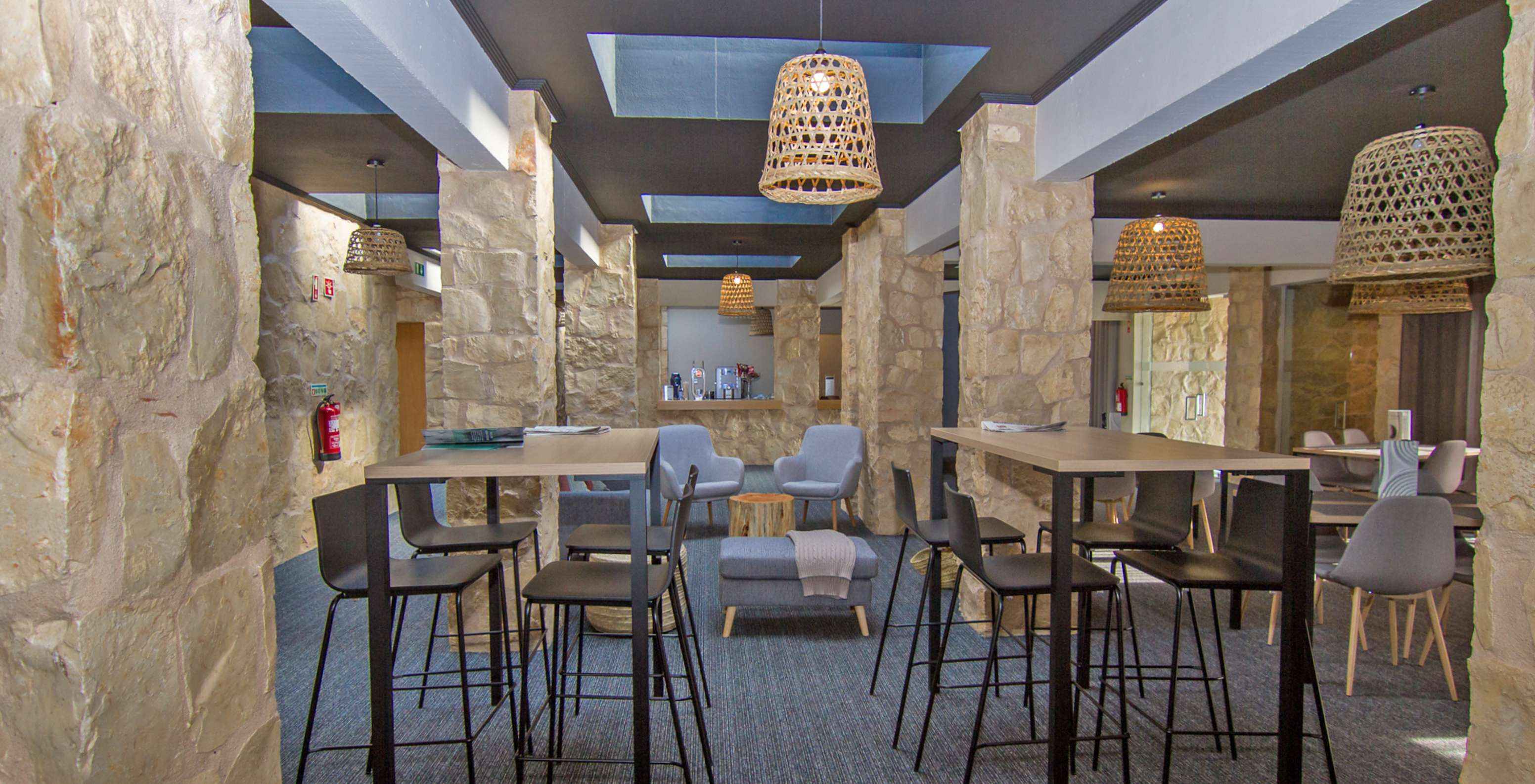 Hotel restaurant with a pool, located on a golf course, with two high tables and tables with comfortable chairs