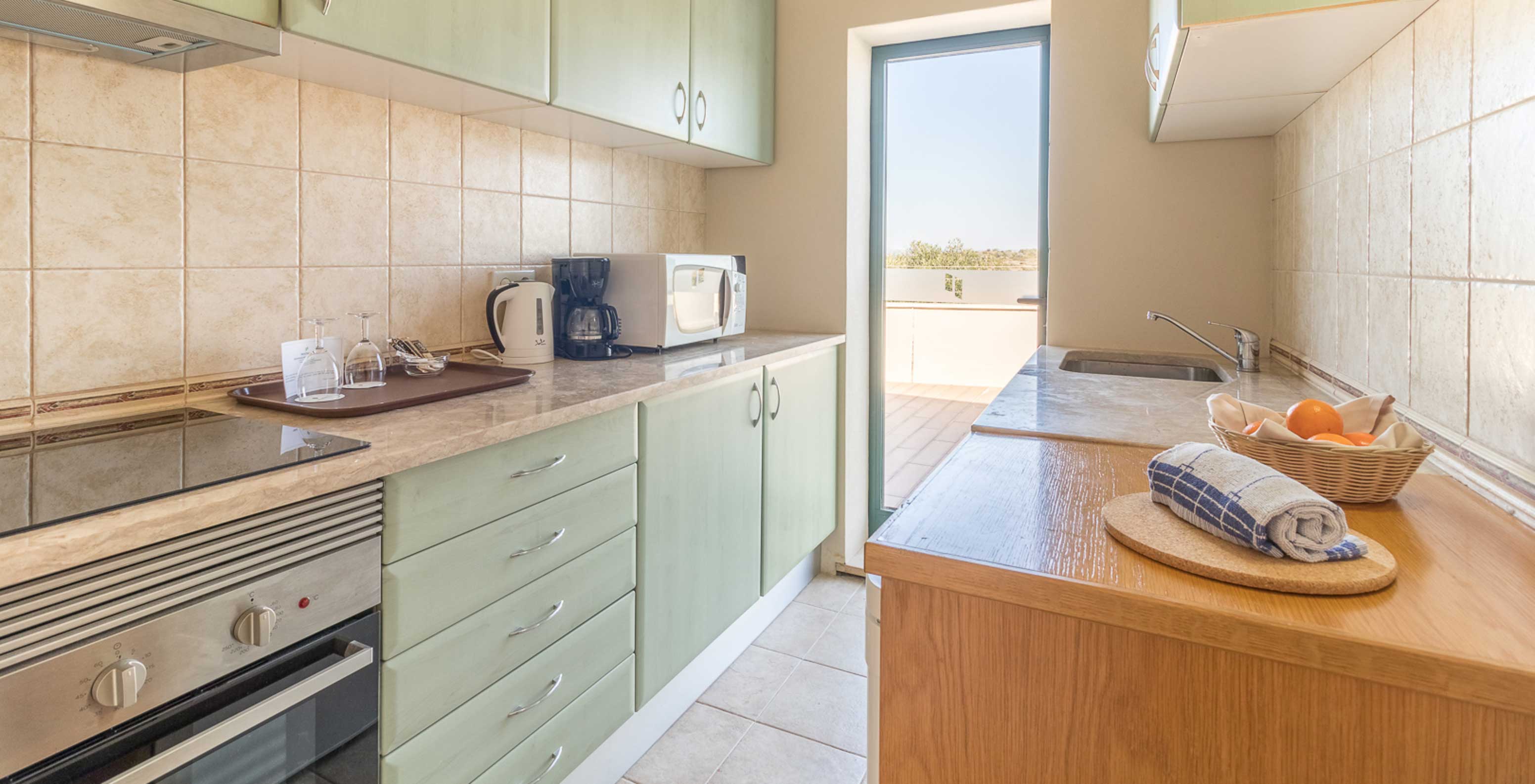 The studio at Pestana Gramacho Residences has a modern kitchen with appliances and access to the balcony