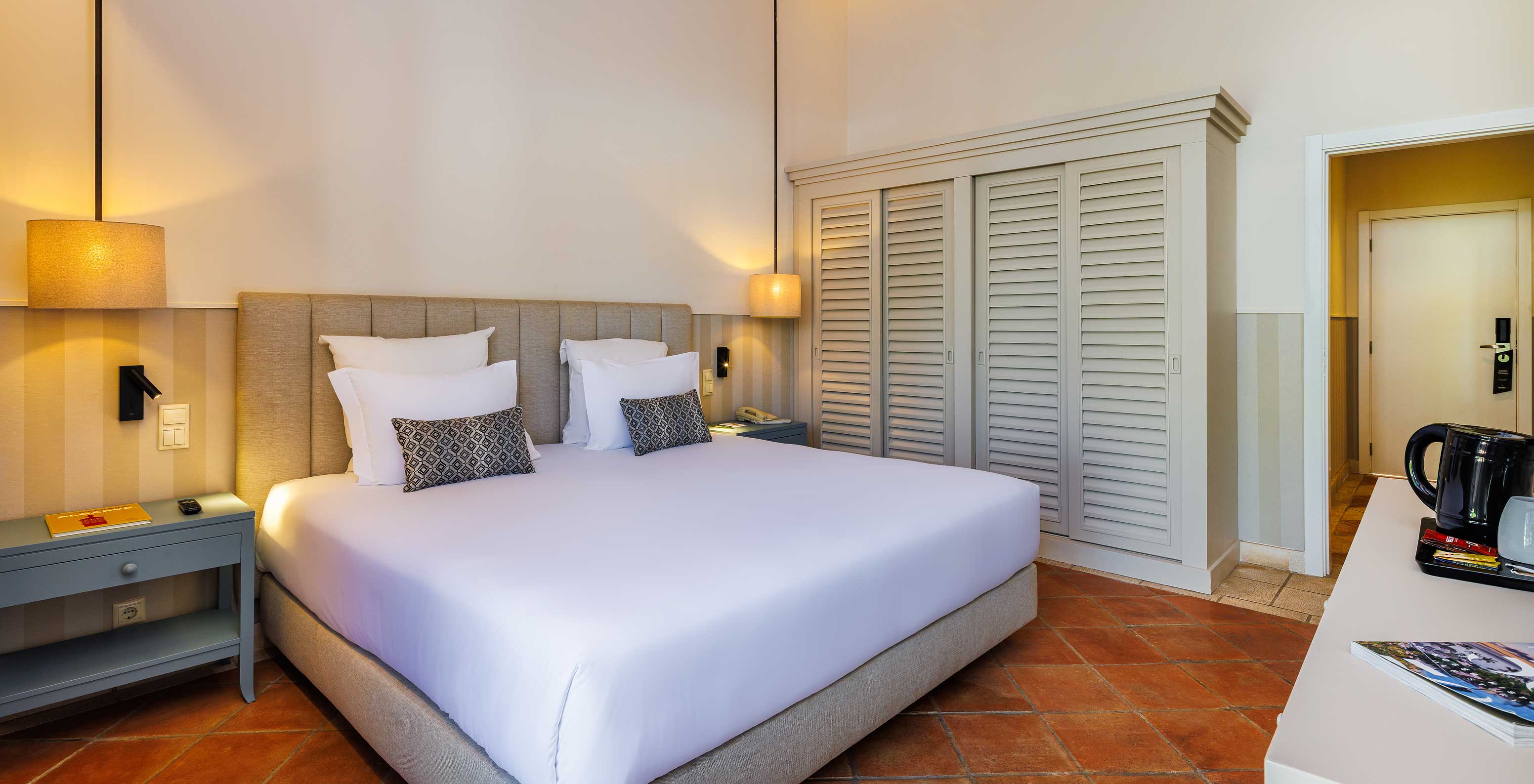 The Family Garden View at Pestana Vila Sol - Vilamoura has a double bed with two nightstands and a large wardrobe