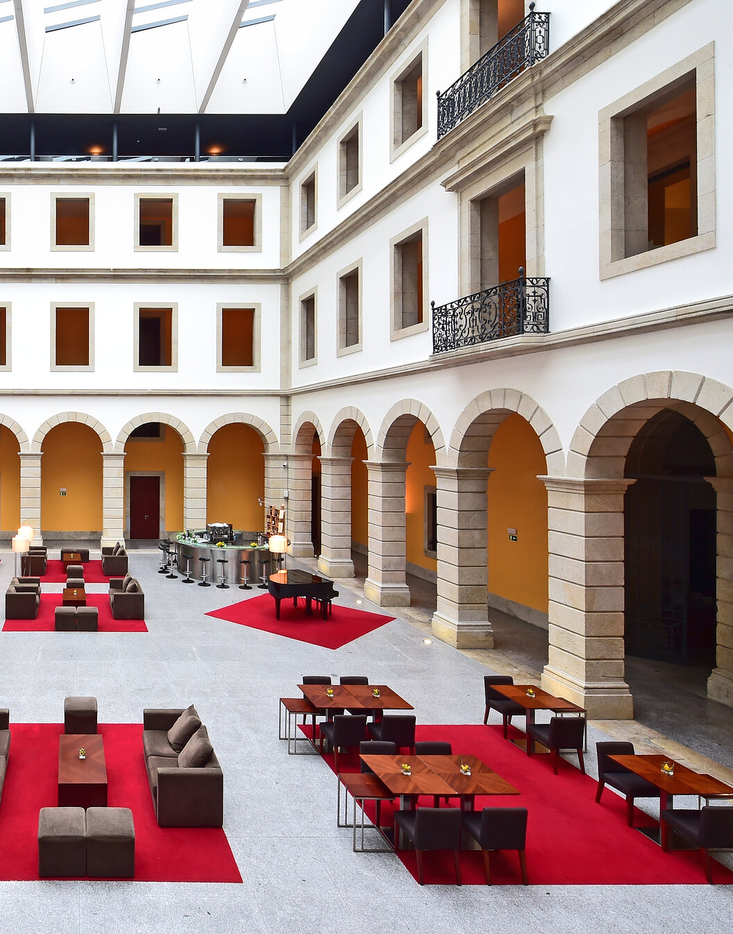 Interior courtyard of Pousada Viseu, historic hotel with arches and sofas, and a bar at the back