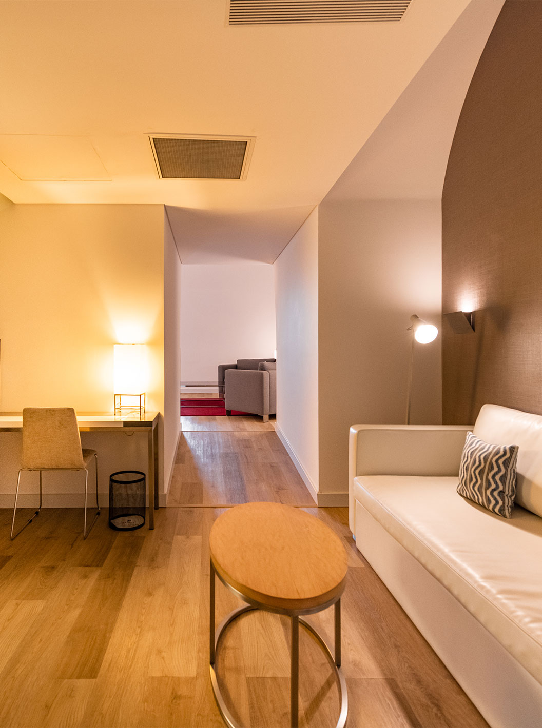 The Junior Family Suite at Pestana Cidadela Cascais has a living room with a sofa, a coffee table, and a desk