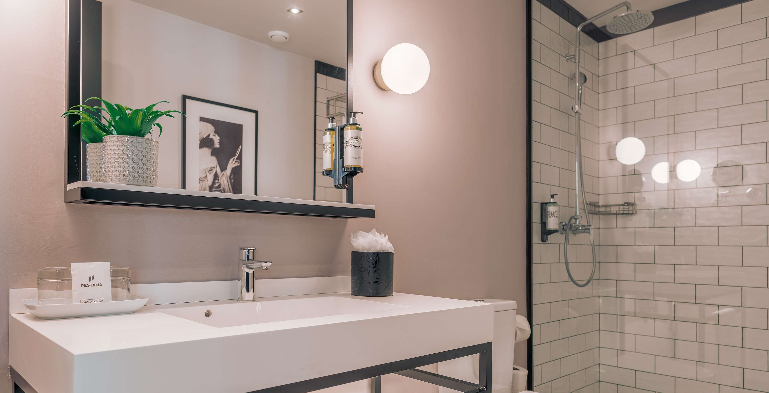 The Junior Suite at Pestana Lisboa Vintage has a bathroom with shower with glass doors with black details and a toilet