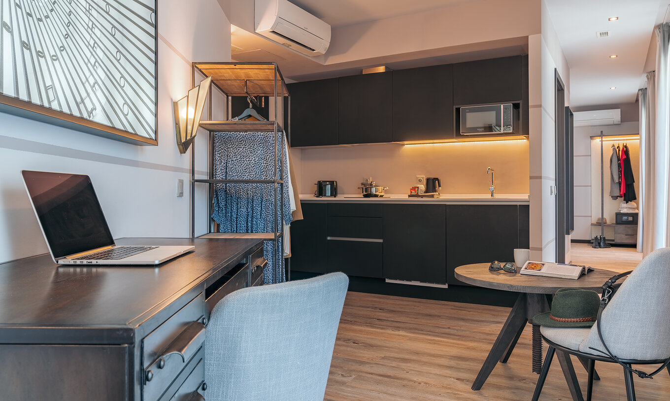 The Rooftop Junior Suite at Pestana Lisboa Vintage has an equipped kitchen, a table, a desk and a wardrobe with clothes