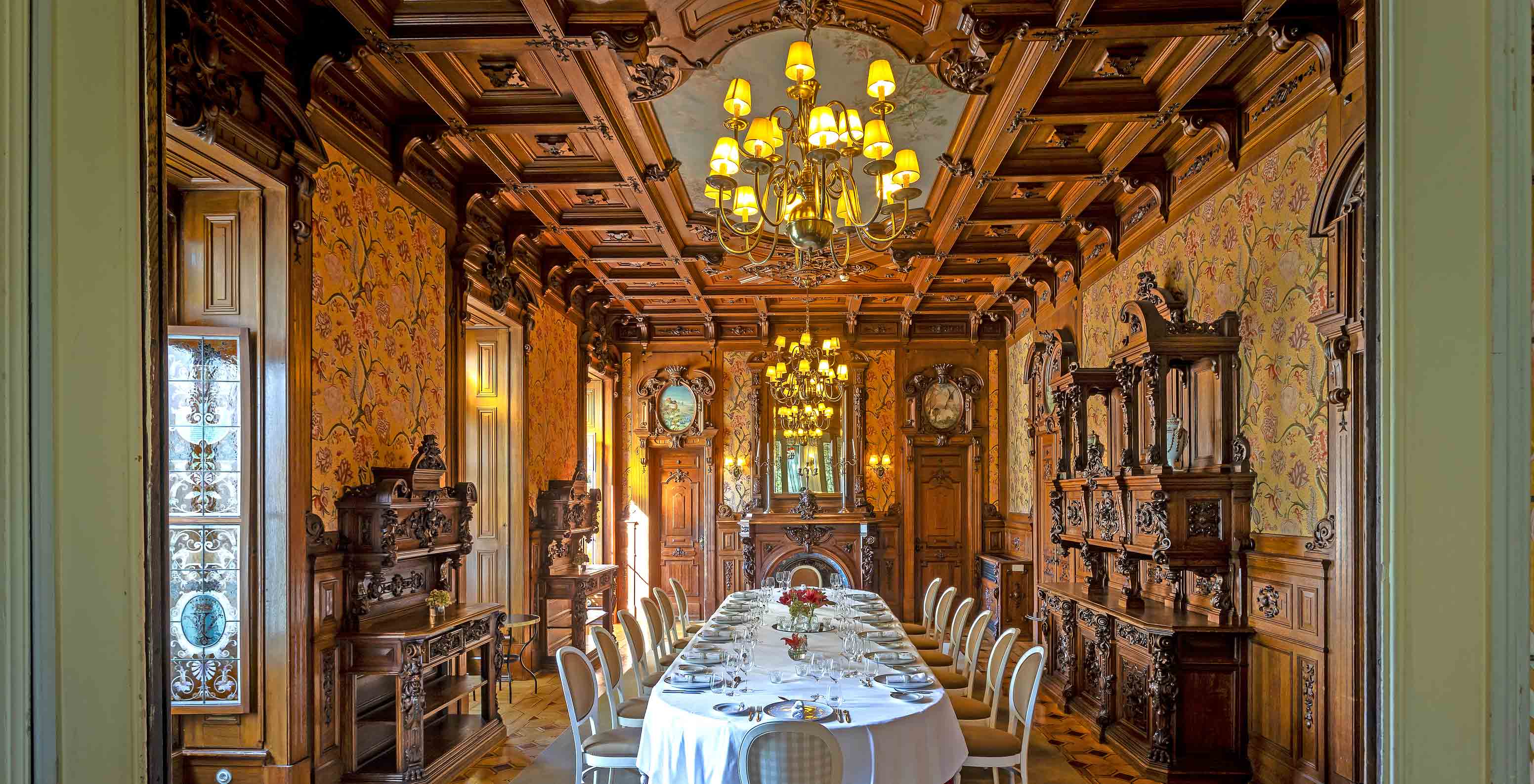 Pestana Palace Lisboa has a private dining room with a wooden ceiling, three chandeliers, and an oval table