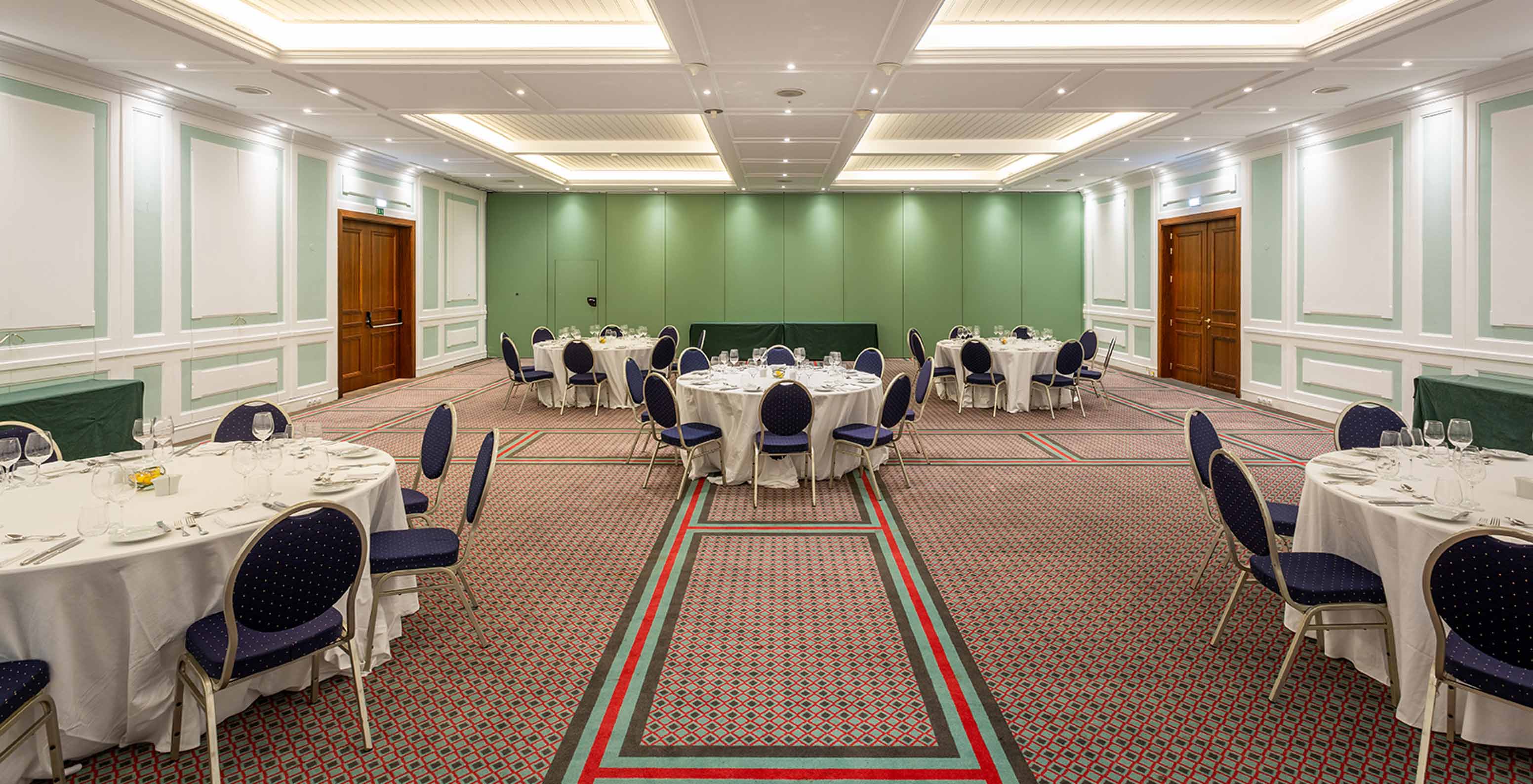 Pestana Palace Lisboa has a large carpeted event room with blue chairs and a green wall