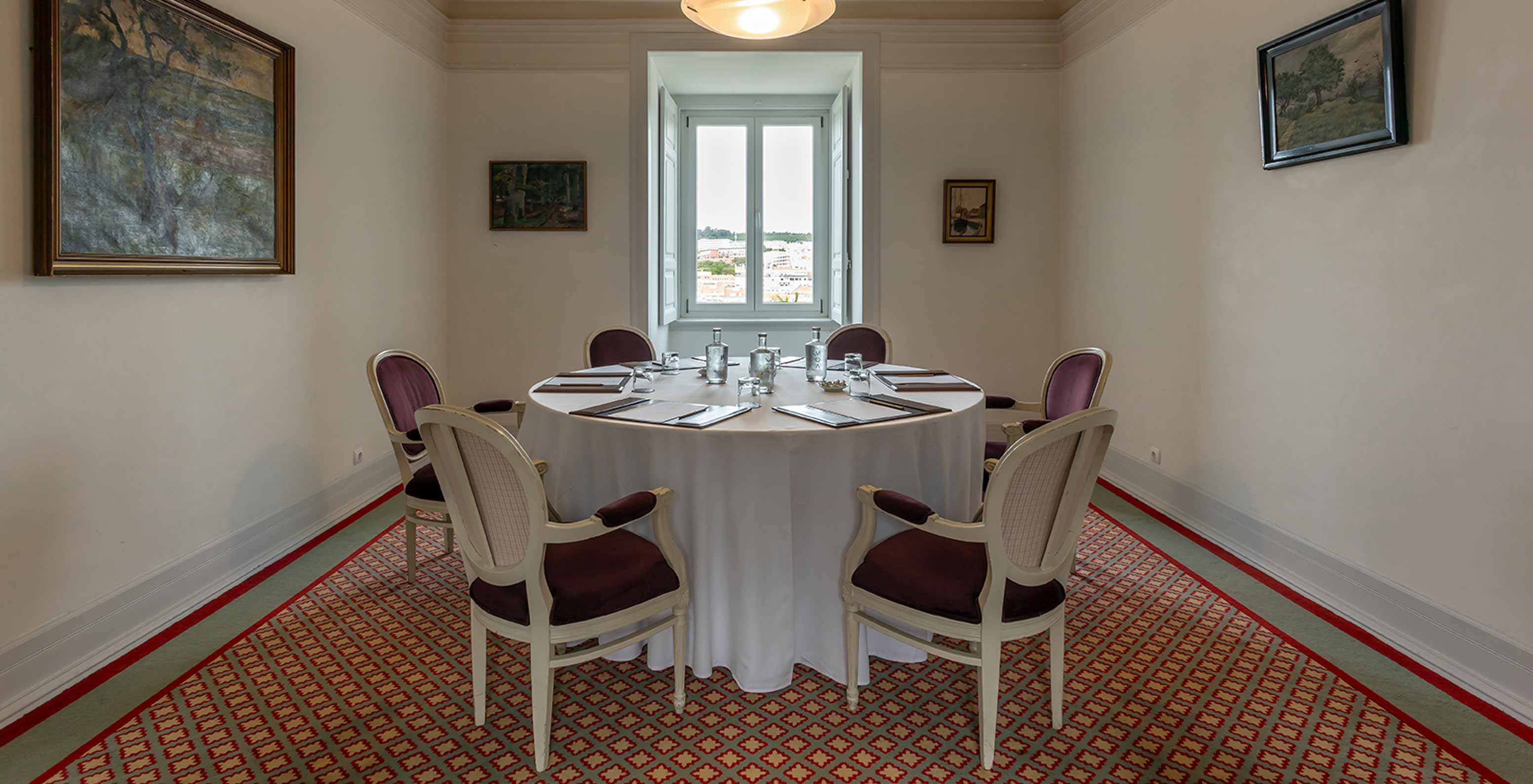 Pestana Palace Lisboa has a meeting room with a round white table surrounded by purple chairs