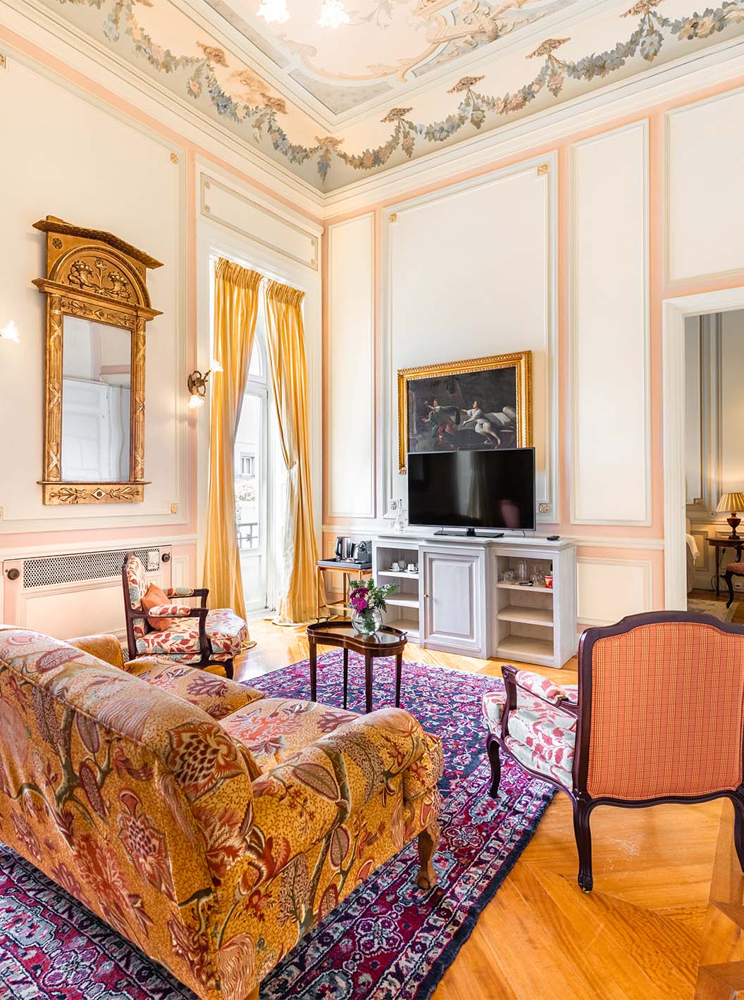 The Suite D. Amélia do Pestana Palace Lisboa has a living room with a sofa, chairs, TV and two large windows