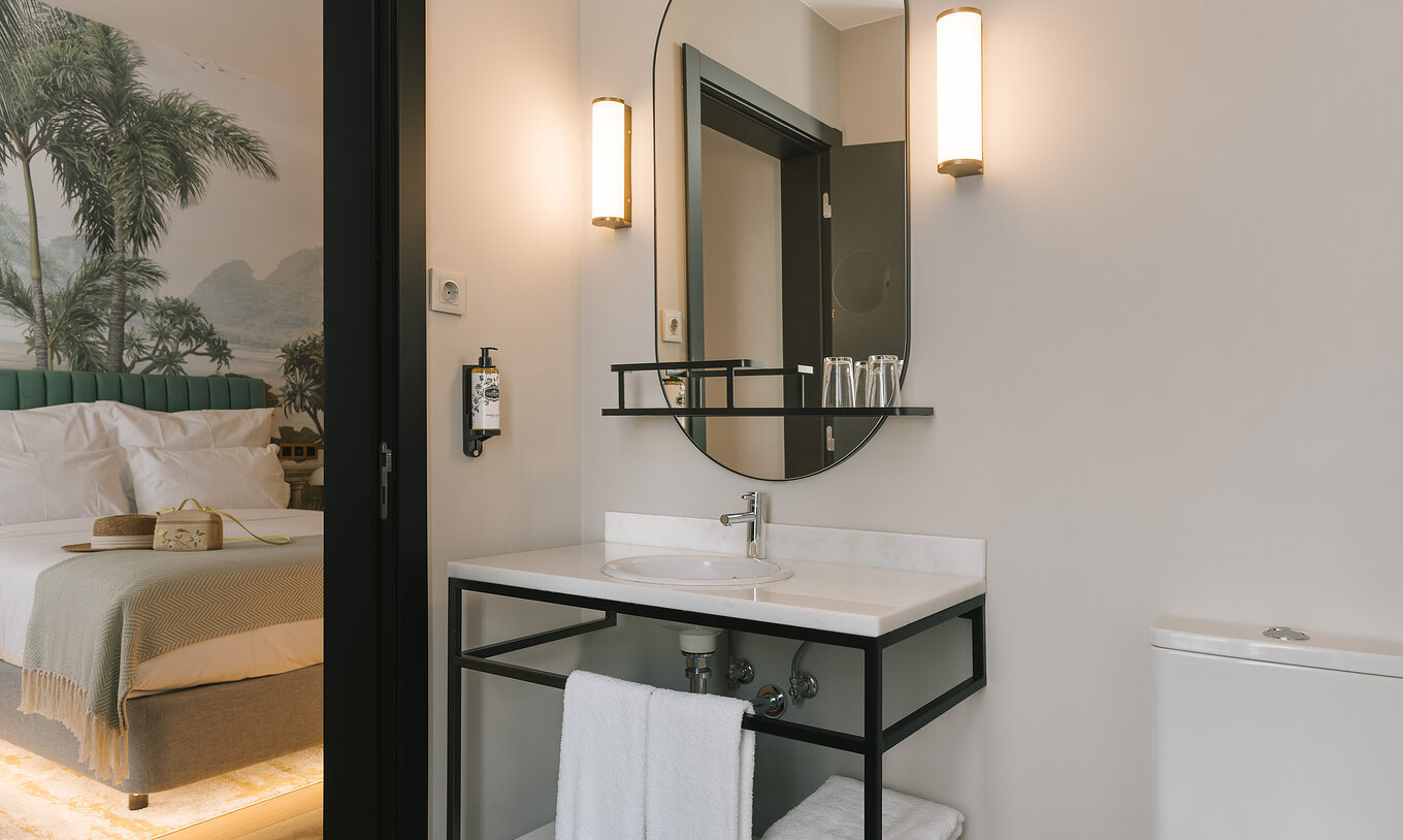 The Superior Room of Pestana Rua Augusta Lisboa has a bathroom with white marble sink, mirror, and towels