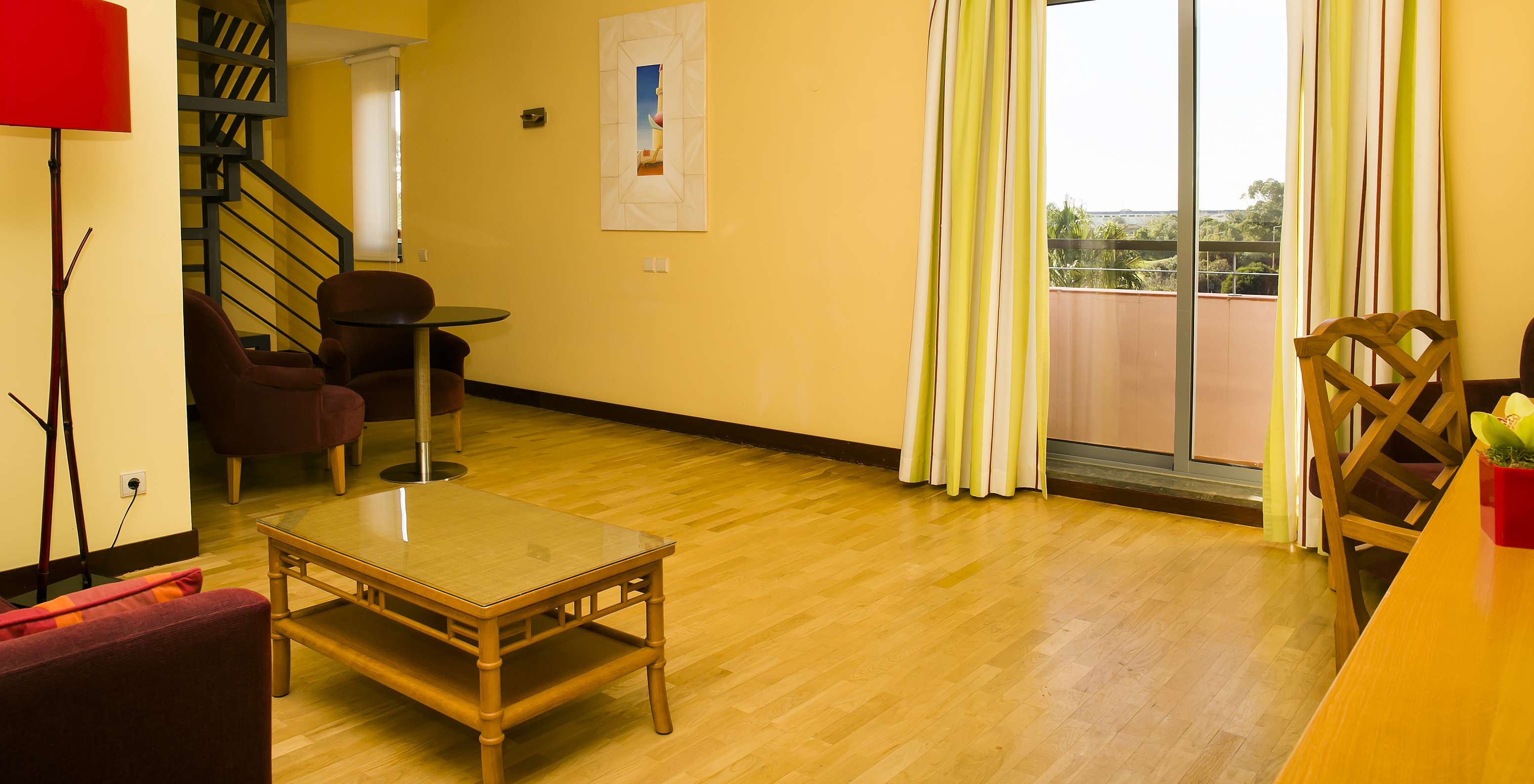The Deluxe Mezzanine Suite of Pestana Sintra Golf has a room with armchairs, coffee table, and window with balcony access