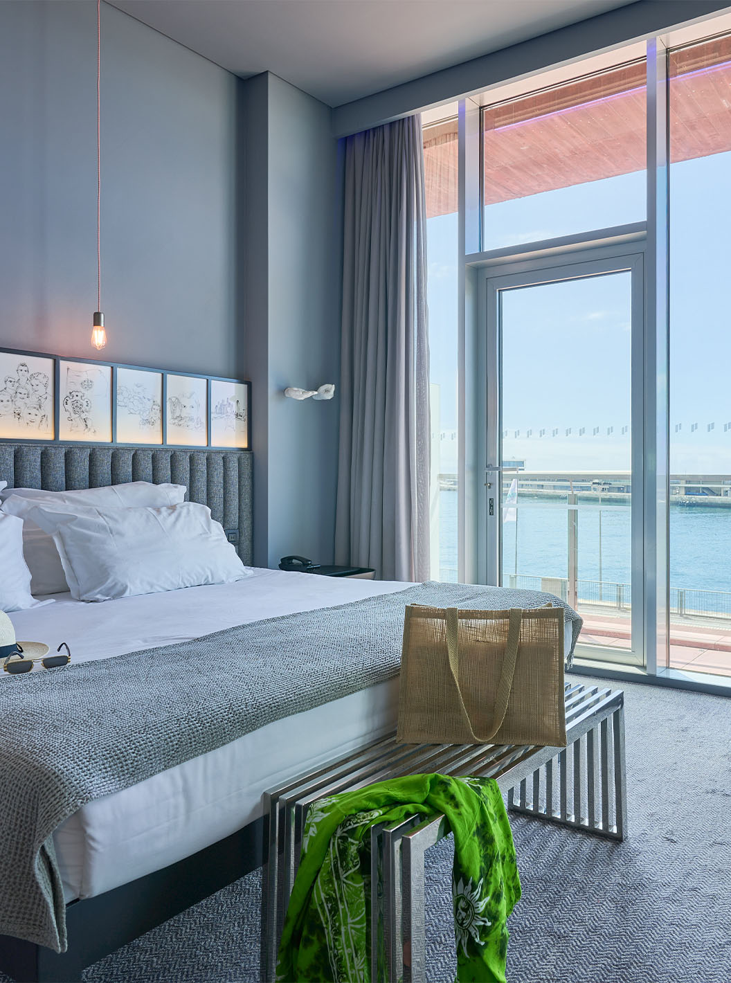 The CR Superior Room at Pestana CR7 Funchal includes a double bed next to the balcony with sea views