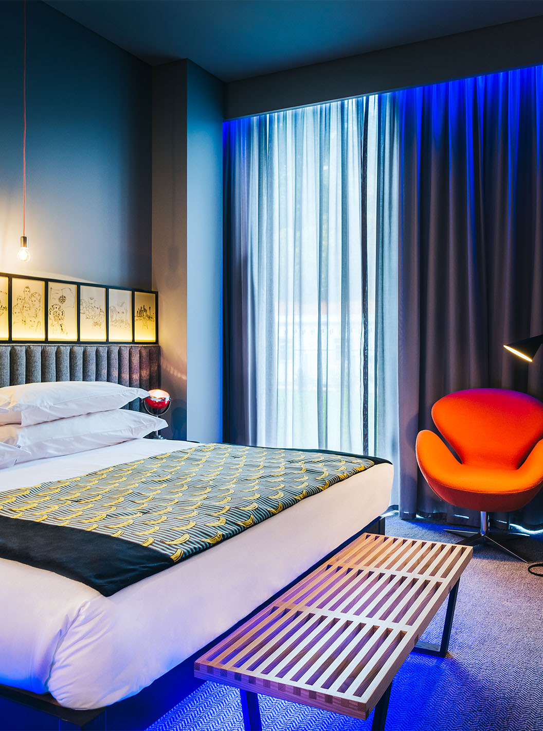 The CR7 Room at Pestana CR7 Funchal has spacious decor with a double bed, a bench, and a comfortable chair