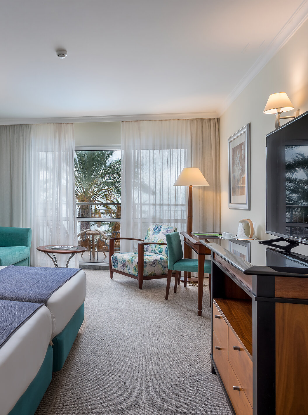 The Twin Superior Sea View Room at Pestana Grand has two single beds, TV and armchair with coffee table