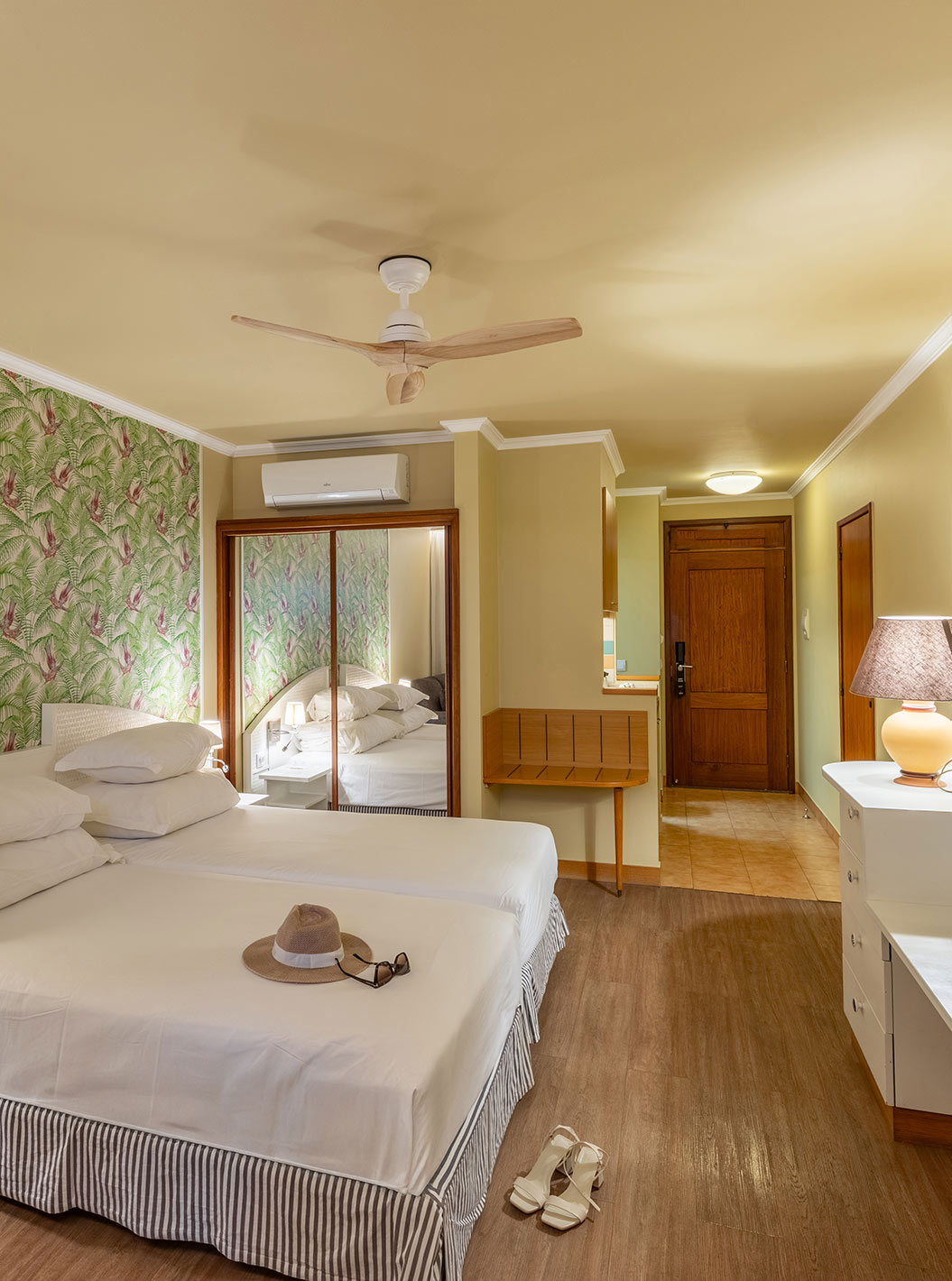 The Pestana Ocean Bay All Inclusive Premium Sea View has a double bed, palm tree wallpaper and a mirror