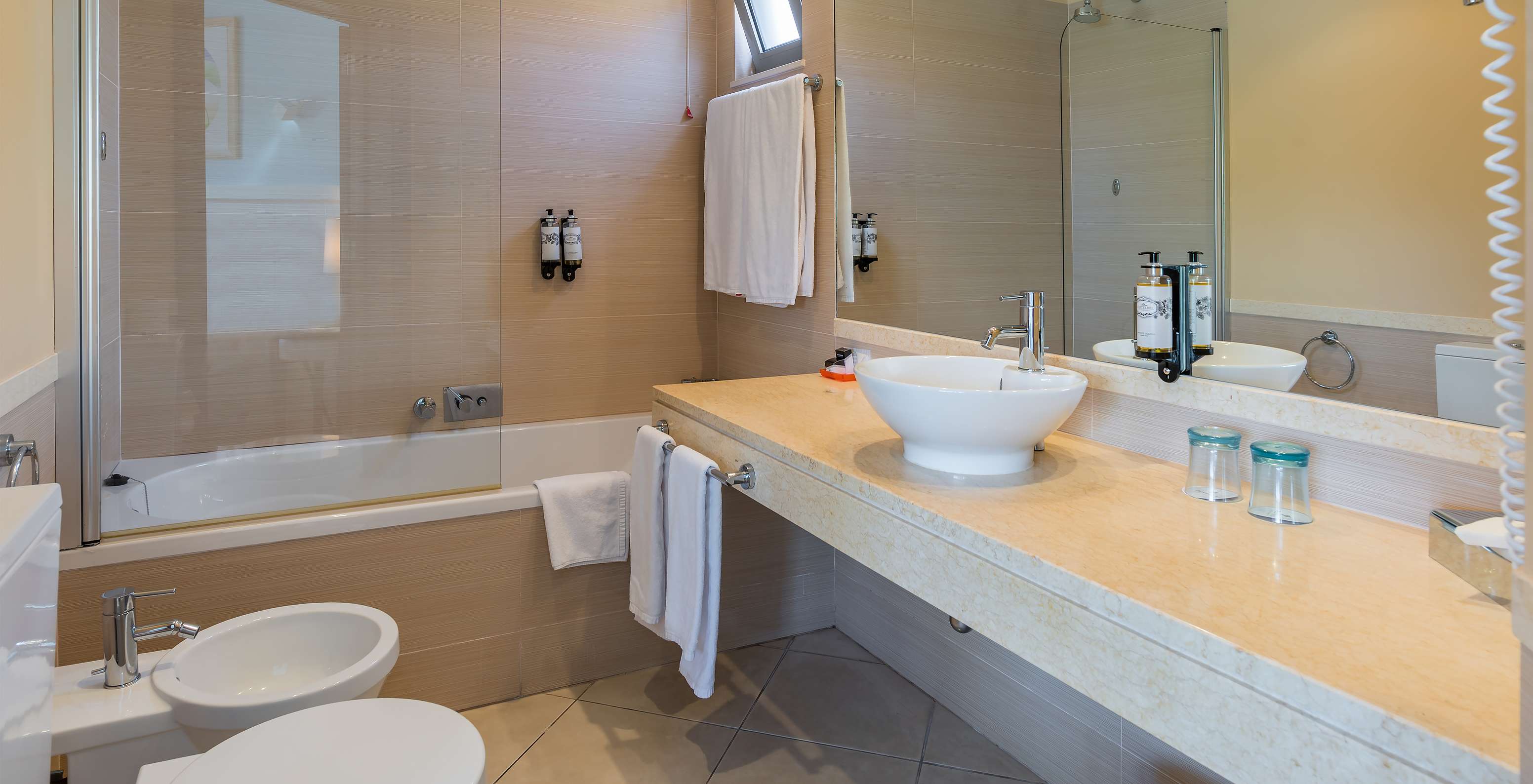 The T1 Suite Apartment of Pestana Porto Santo All Inclusive has a bathroom with bidet, sink, mirror, and bathtub