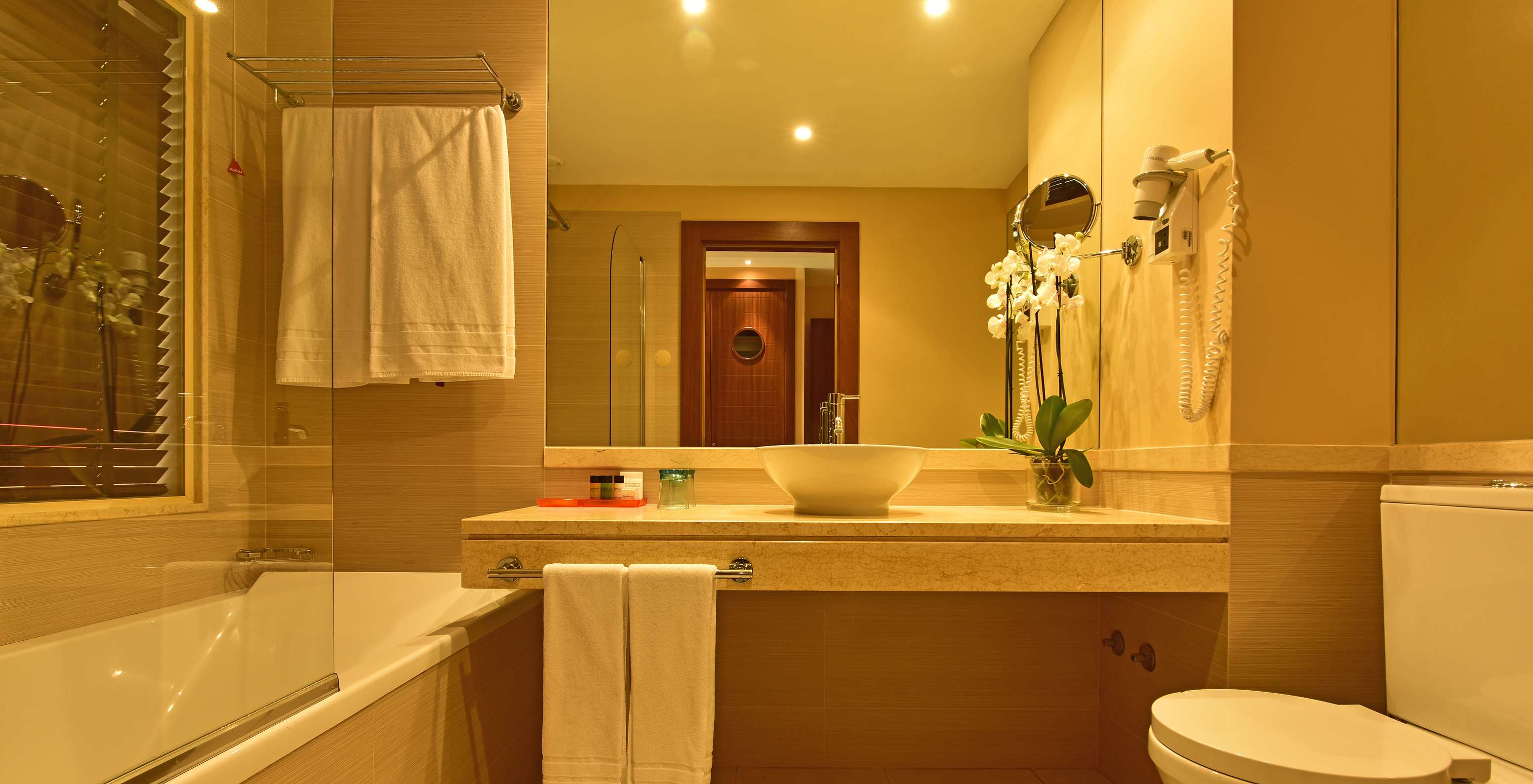 The T2 Suite Apartment of Pestana Porto Santo All Inclusive has a bathroom with sink, towels, mirror, and toilet