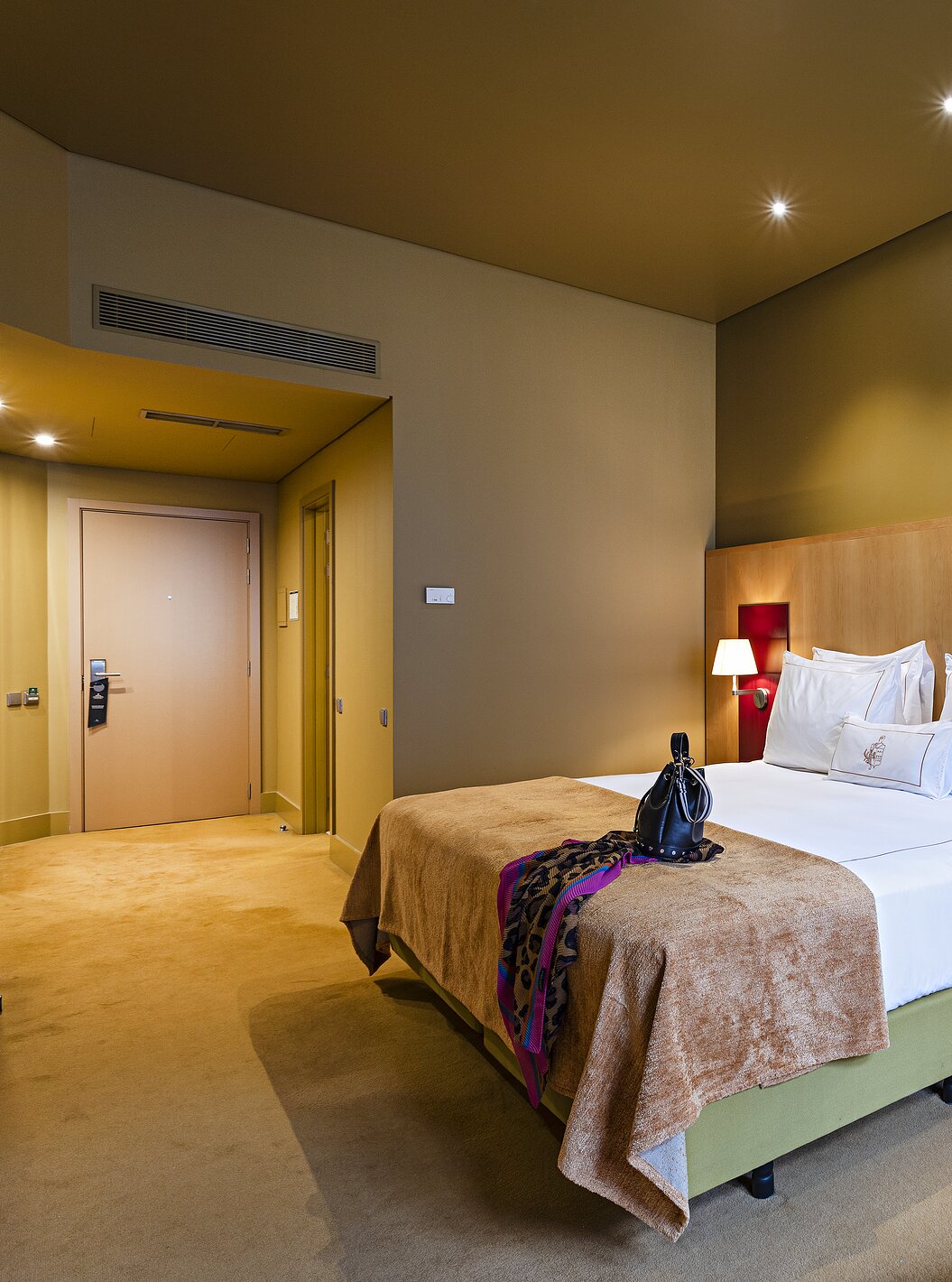 Pestana Palácio do Freixo’s Classic room has yellow walls, a double bed, and a beige sofa bed