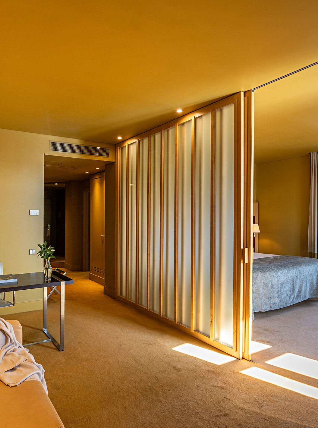 The Standard Suite has a double bed with a partition to the living room with sofa and desk