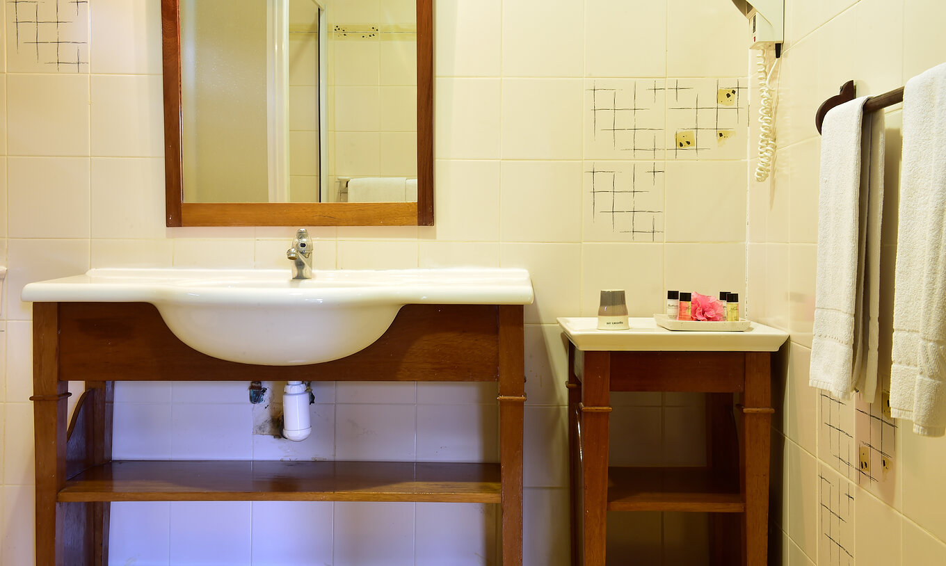 The Standard Suite at Pestana Equador Ilheu das Rolas has a bathroom with a table and a sink with a mirror