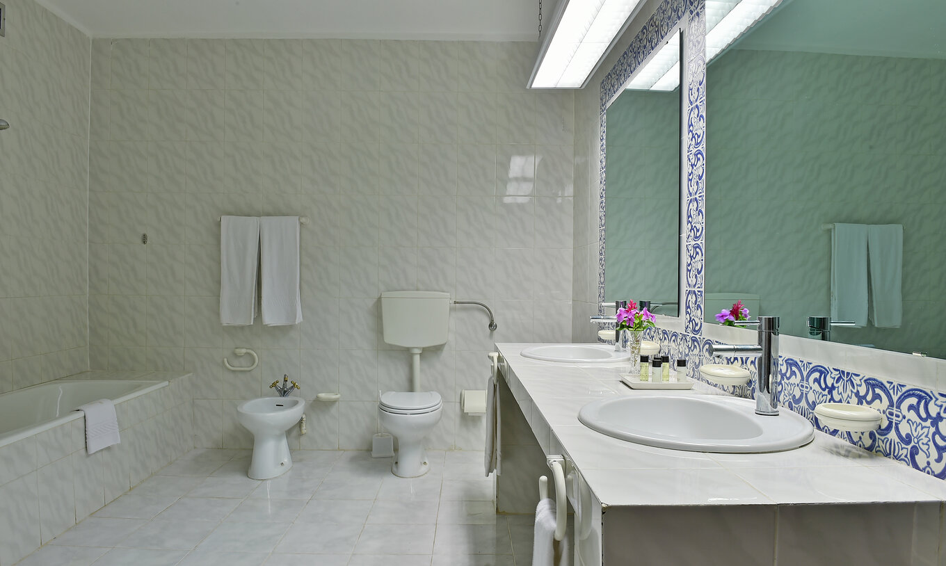 The Presidential Suite at Pestana Miramar São Tomé features a bathroom with two sinks, mirrors, a bidet, and a toilet