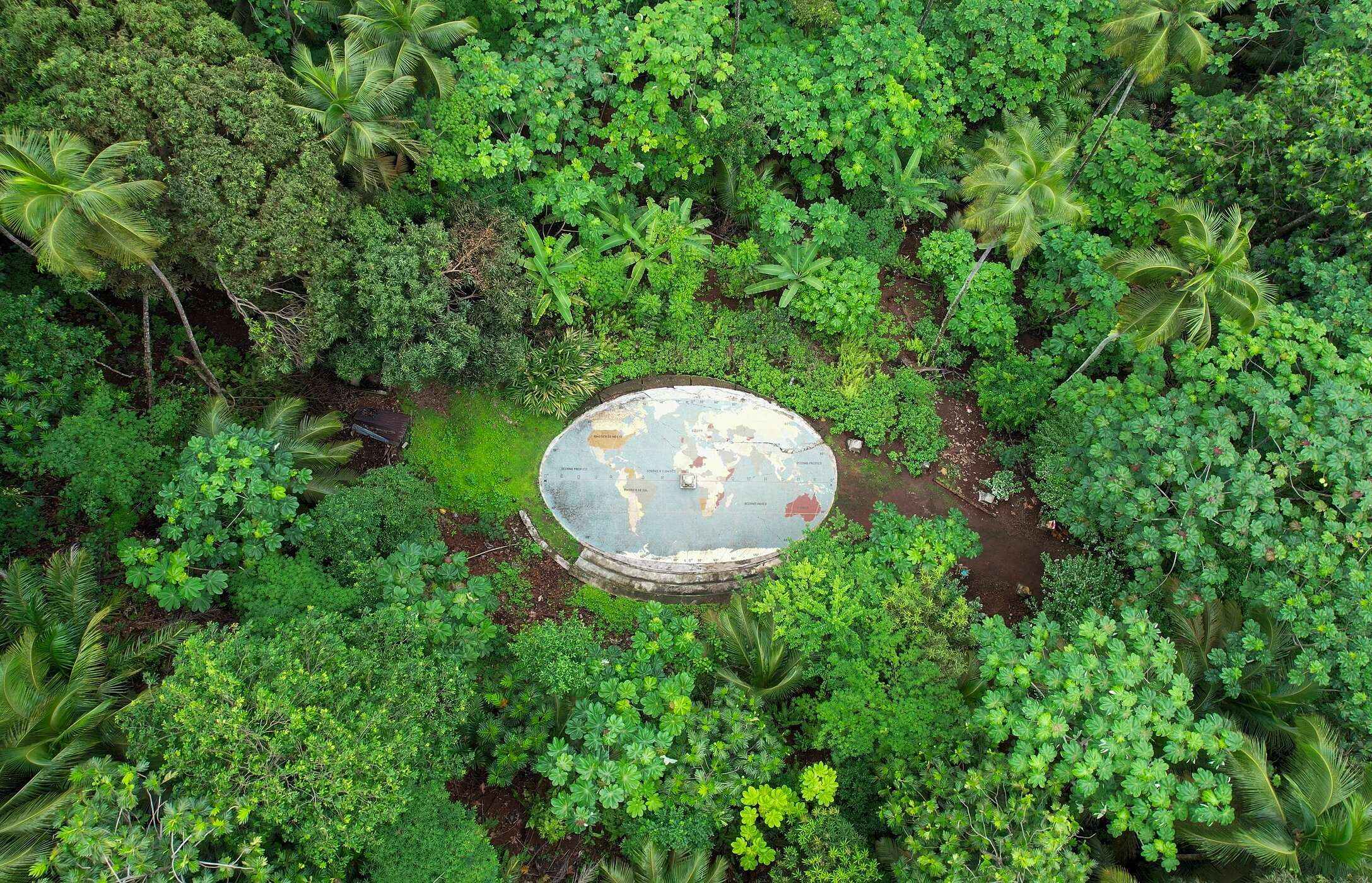 Equator marker, with a world map, in the middle of the forest on the island of São Tomé