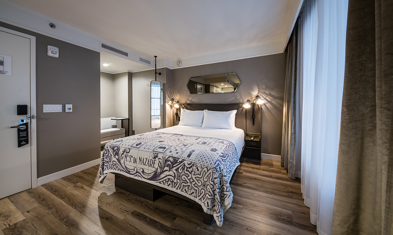 The Junior Suite - ADA at Pestana Park Avenue has a double bed, mirror and lamp