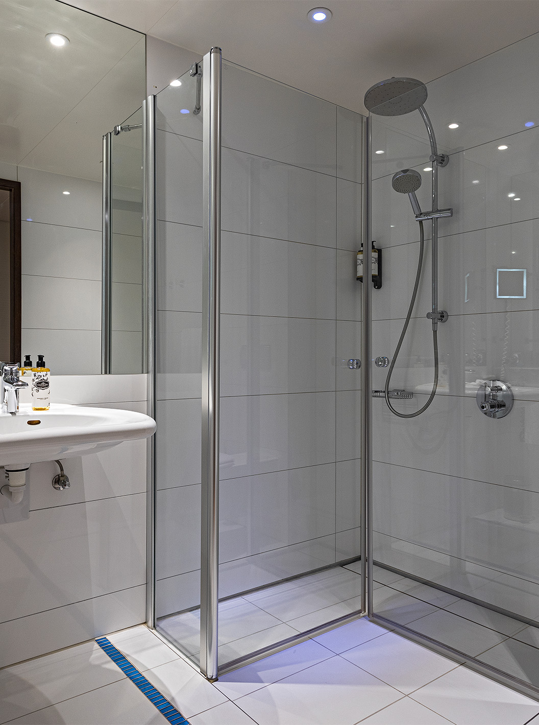 El Cuarto Deluxe con Balcón del Pestana Berlin Tiergarten tiene baño con ducha, un lavabo y un espejo