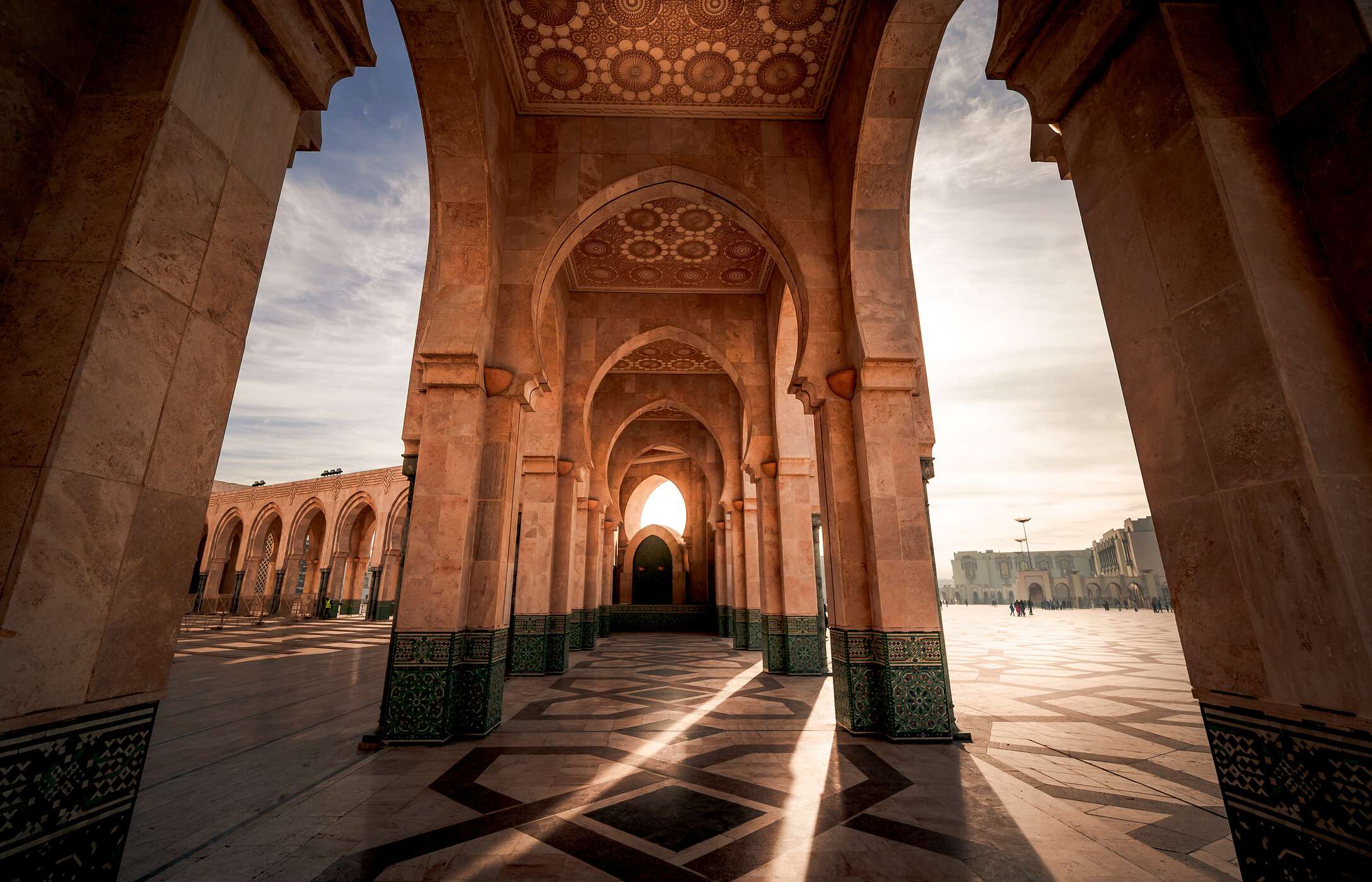 Vista en las arcadas de la Mezquita Hassan II en Casablanca, con la luz de la tarde incidiendo en la arquitectura