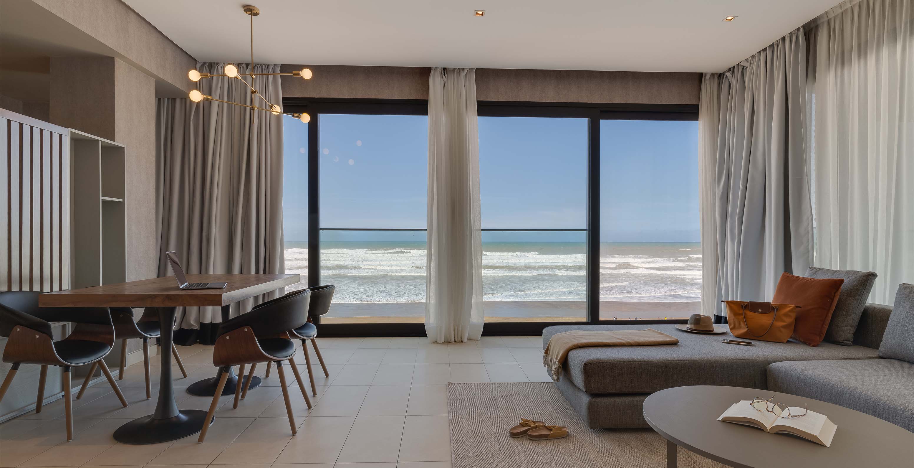 La Suite Familiar Corniche del Pestana Casablanca tiene sala con sofá y vista espectacular sobre la playa