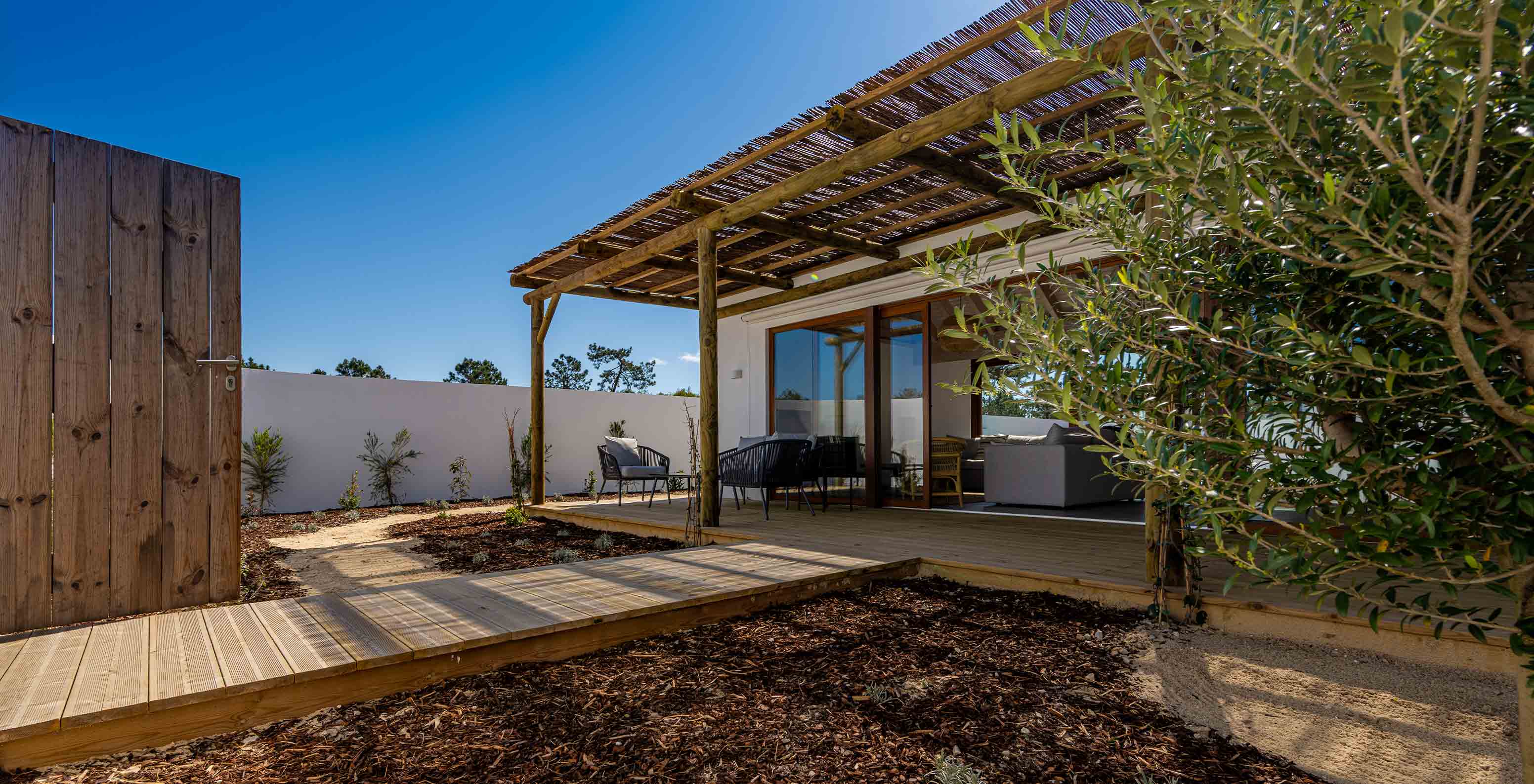 La Premium Green Villa de Pestana Comporta Village Residences tiene un patio con deck de madera y una pérgola que da sombra
