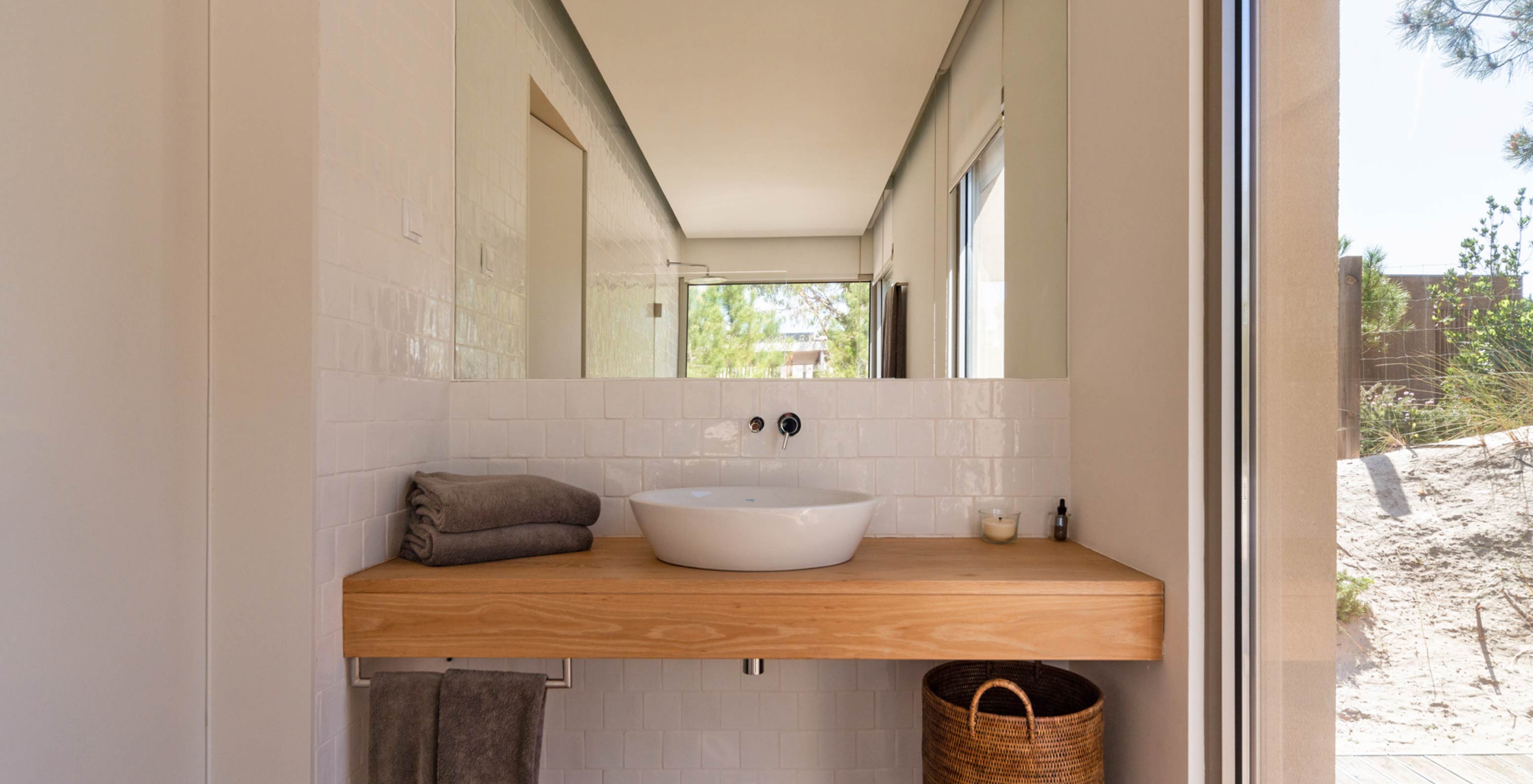 La villa exclusiva con piscina del Pestana Tróia Eco Resort tiene un baño con lavabo, encimera de madera y espejo