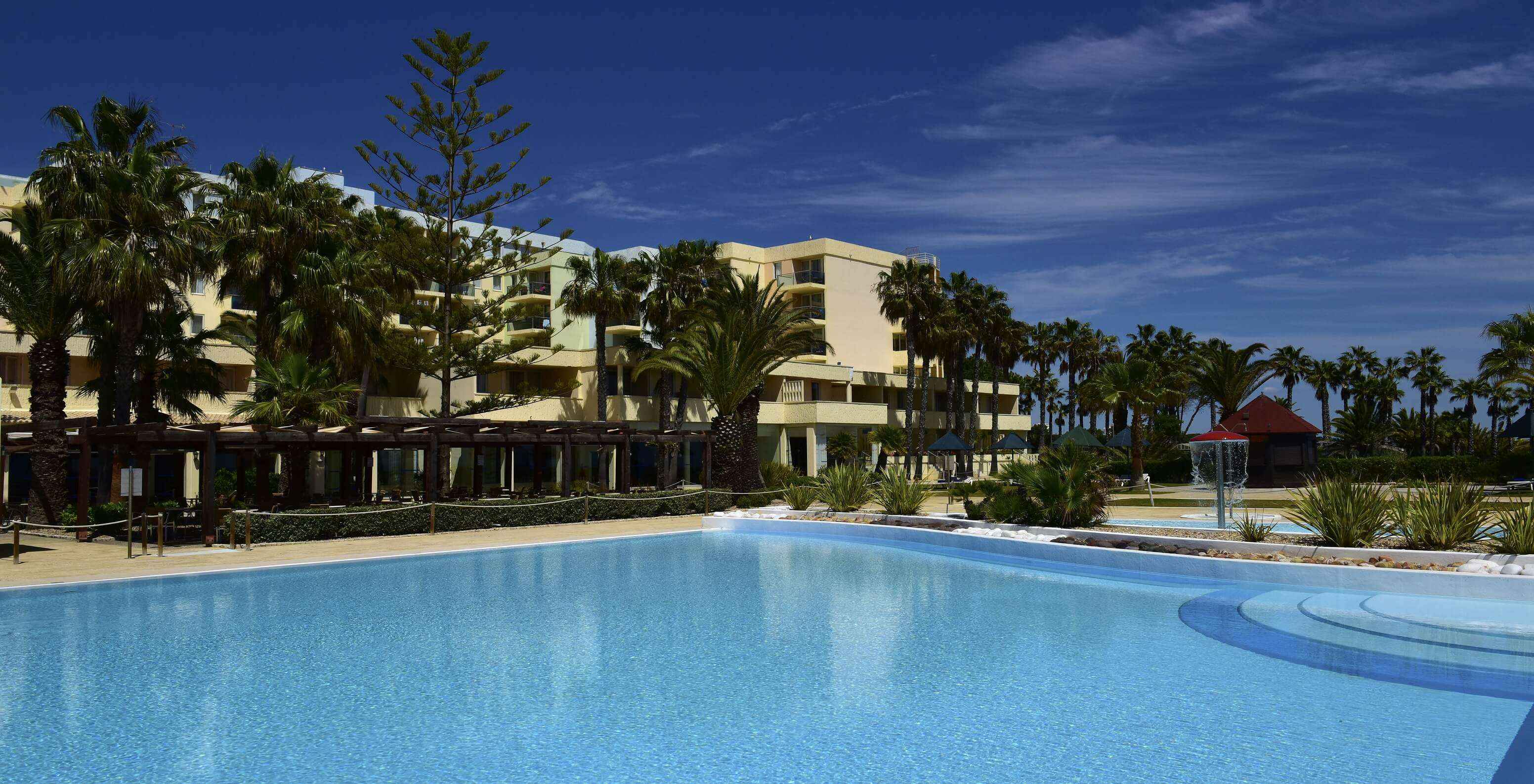 Piscina exterior del Pestana Viking en un día soleado, con un bar y una pequeña piscina para niños